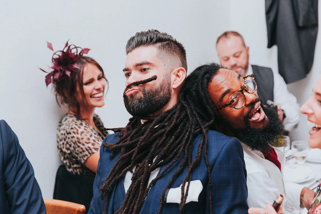 Wedding guest playing with another guest's dreadlocks and using one as moustache  at St John Restaurant, Smithfield for a City of London Wedding.