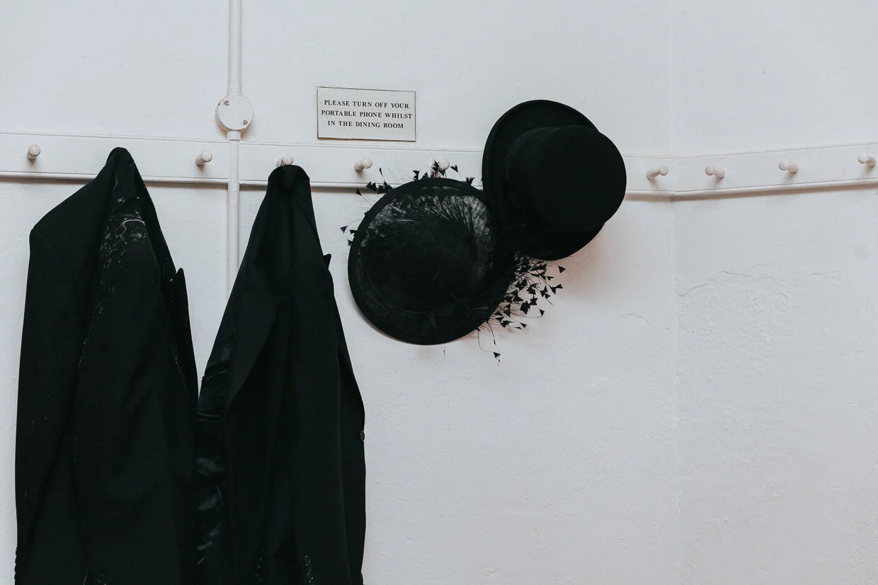 Hats and jackets on pegs at a St John Restaurant Wedding.