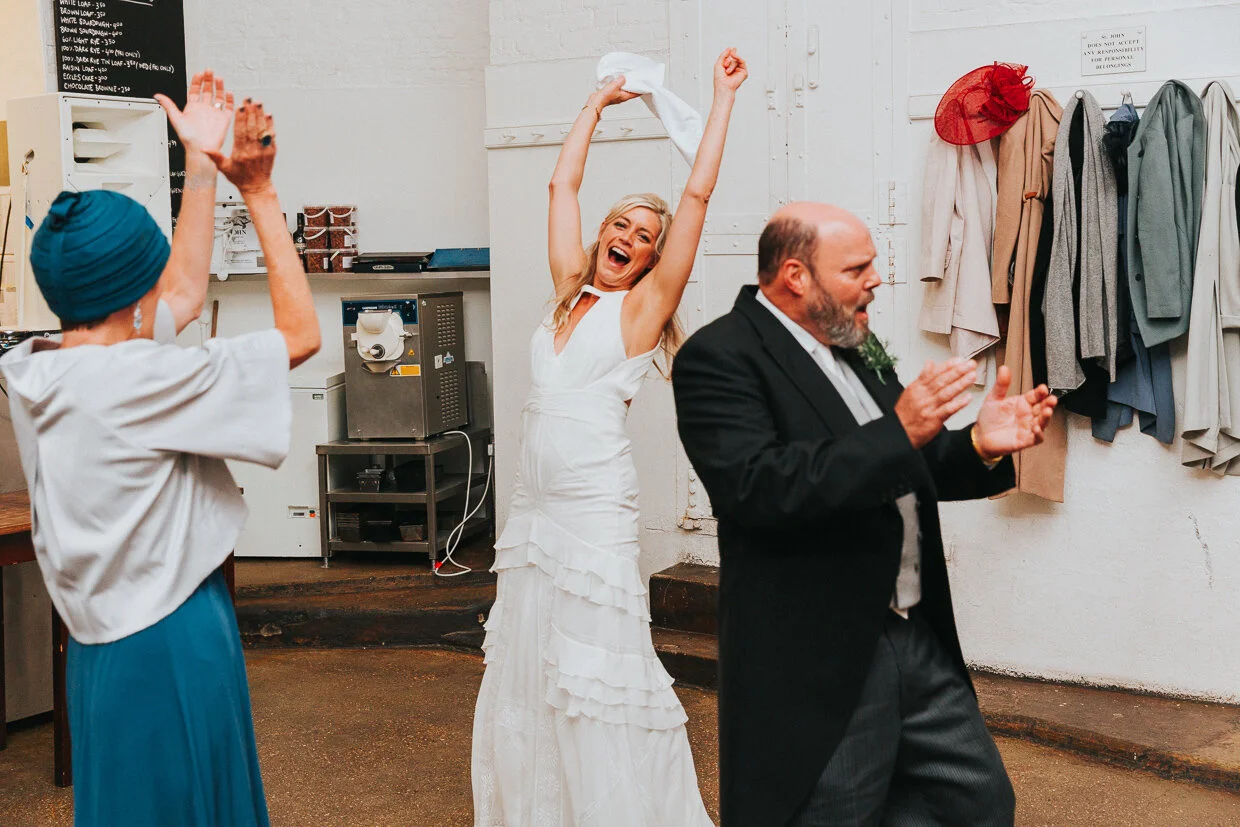 Bride dancing waving a napkin and her parents at St John Restaurant, Smithfield for a City of London Wedding