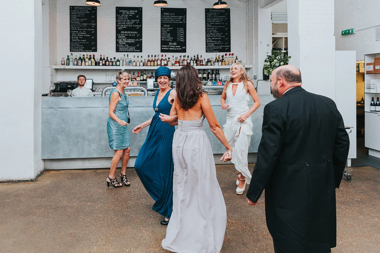 A group of Wedding guests with the Bride dancing around St John Restaurant, Smithfield for a City of London Wedding