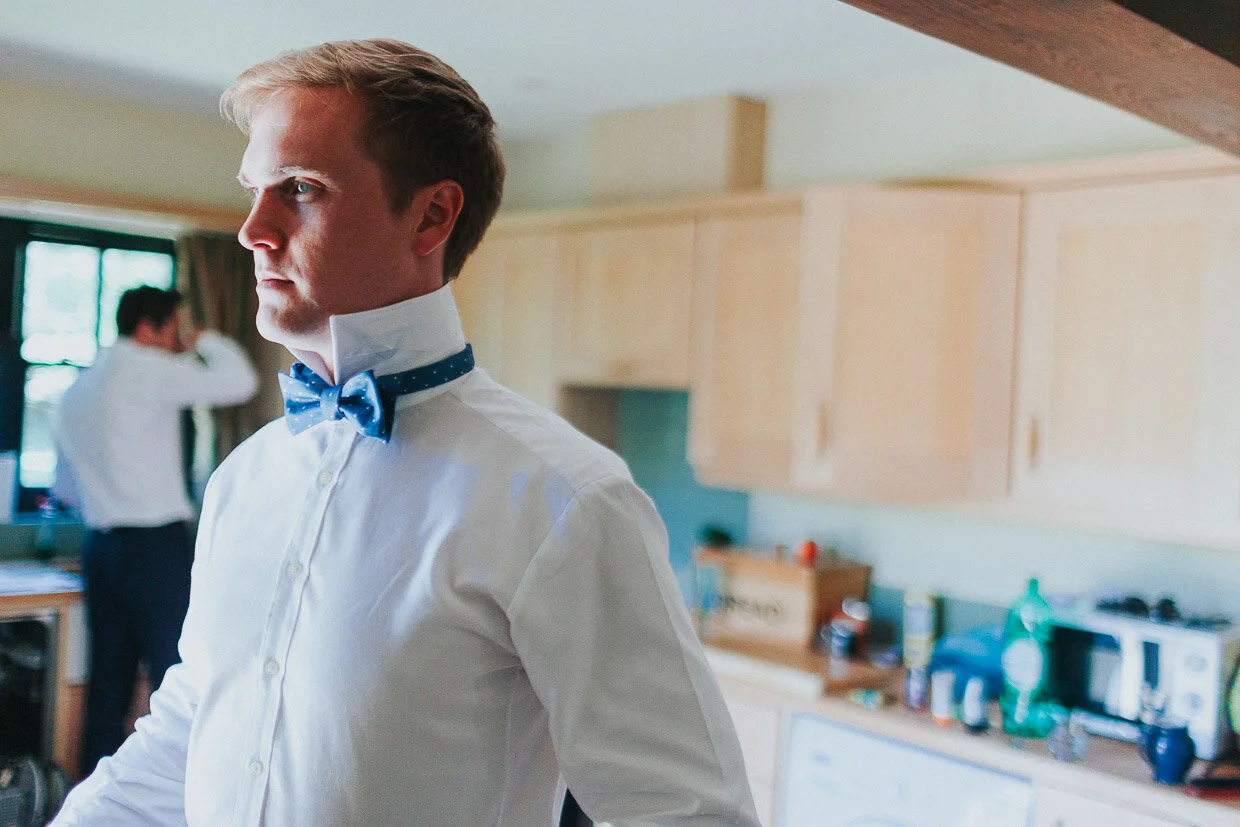 Groom looking serious with shirt collars up and bow-ties done up on the Ballynatray Estate for a Cork Wedding