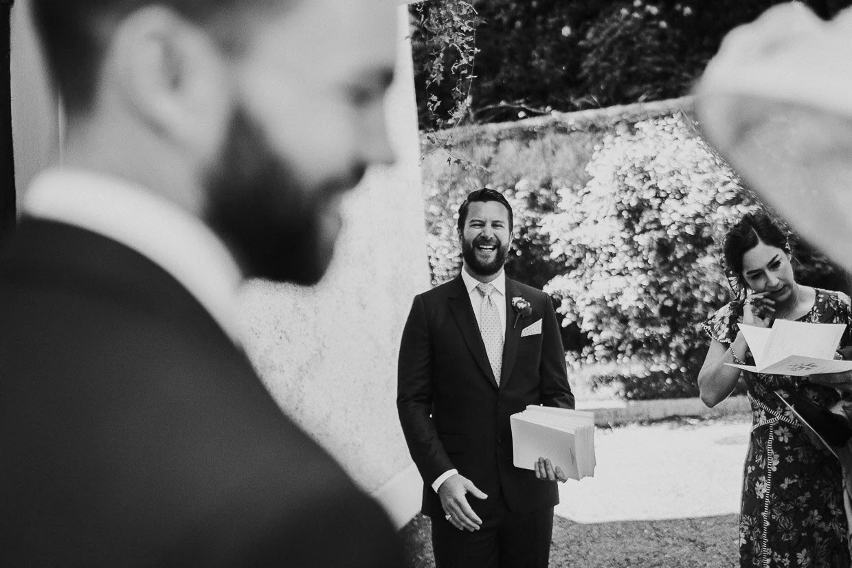 Bestman laughing outside church handing out order of service on the Ballynatray Estate for a Cork Wedding