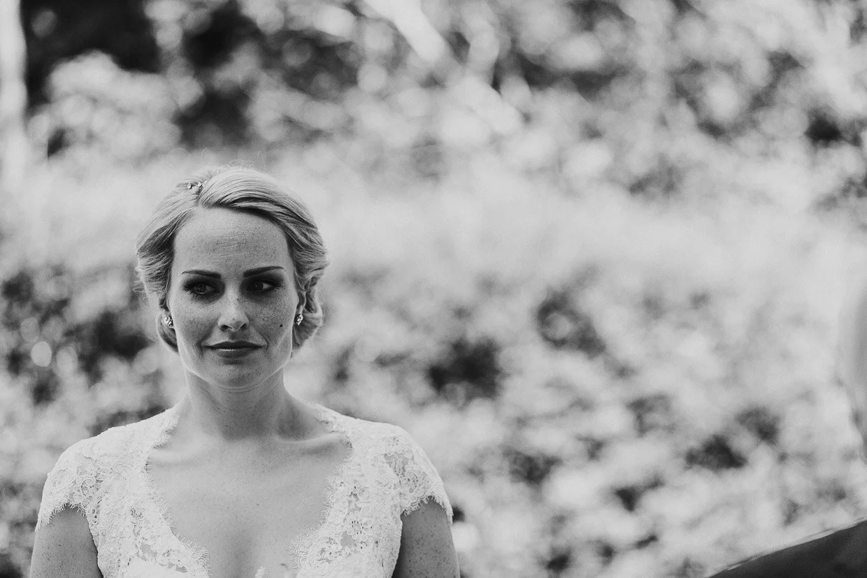 Bride outside the church alone with a slight smile on the Ballynatray Estate for a Cork Wedding