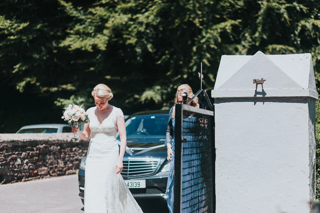 Bride walking from wedding car towards the church on the Ballynatray Estate for a Cork Wedding