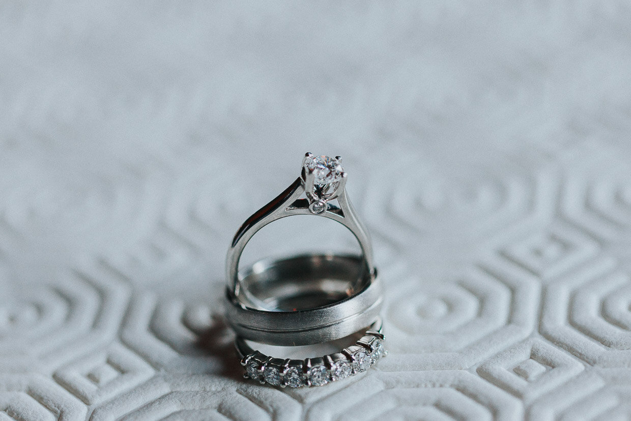 A image of the wedding and engagement rings stacked on a textured surface on the Ballynatray Estate for a Cork Wedding