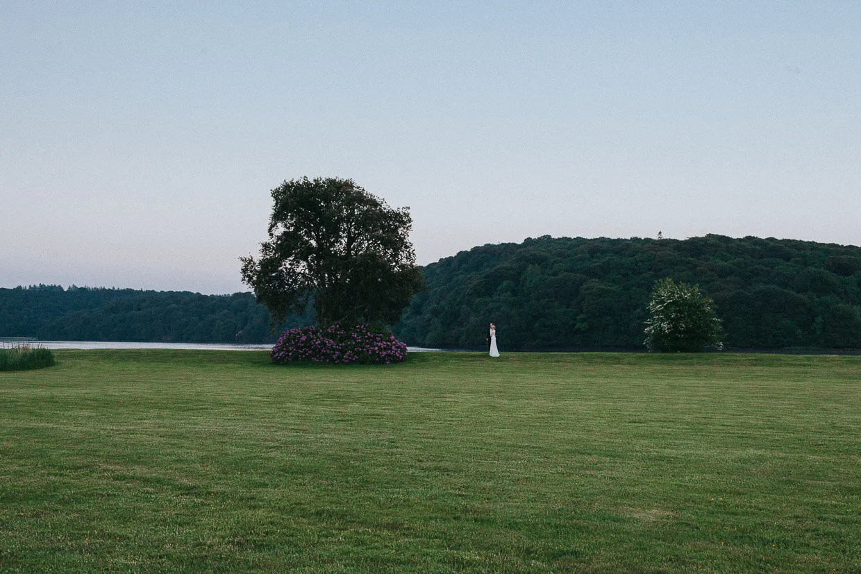 Wedding couple posing in the distance next to the Lake on the grounds Wedding couple dancing, facing each other for their first dance in between spotlights on the Ballynatray Estate for a Cork Wedding