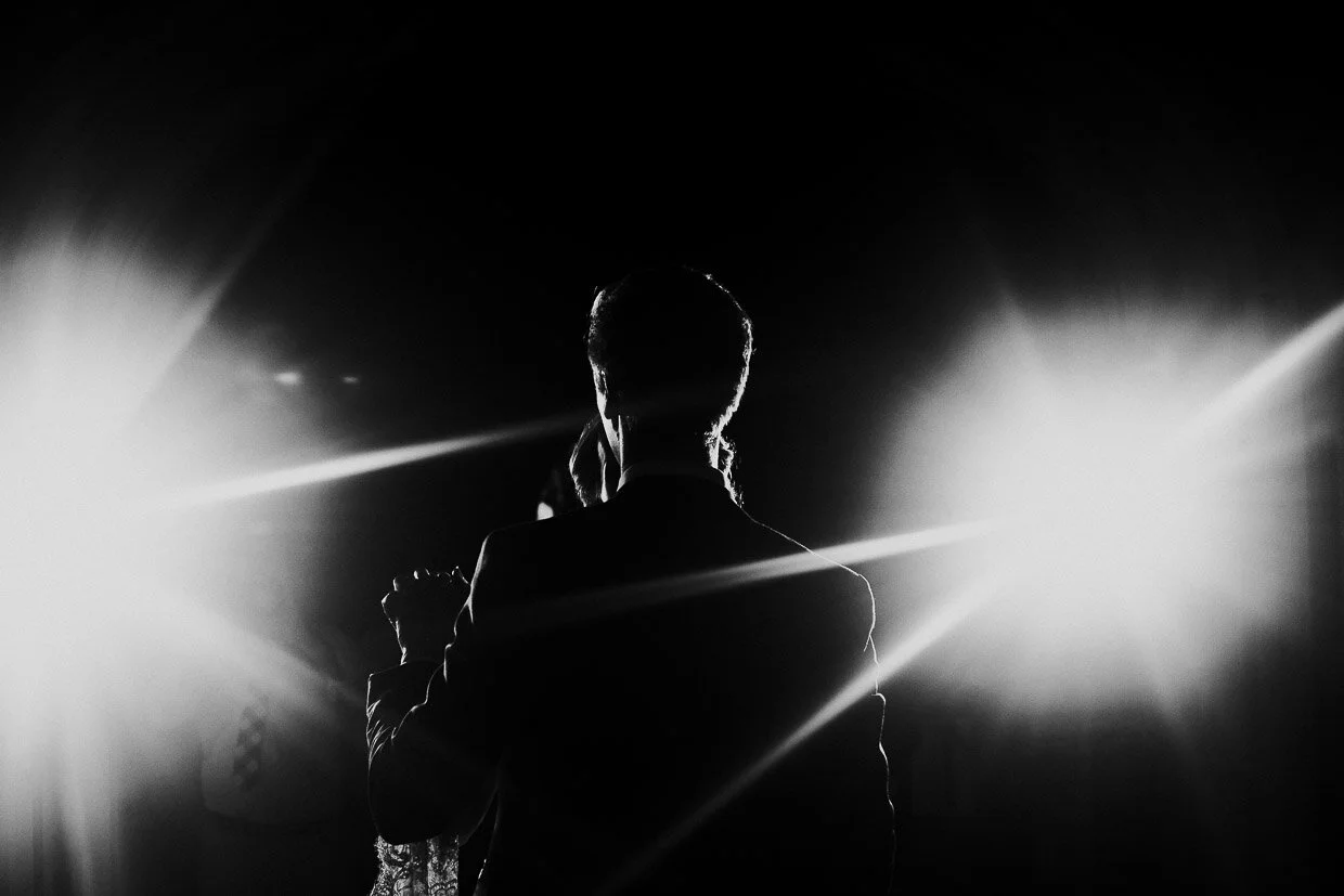 Wedding couple dancing,with grooms back to the camera for their first dance in between spotlights on the Ballynatray Estate for a Cork Wedding