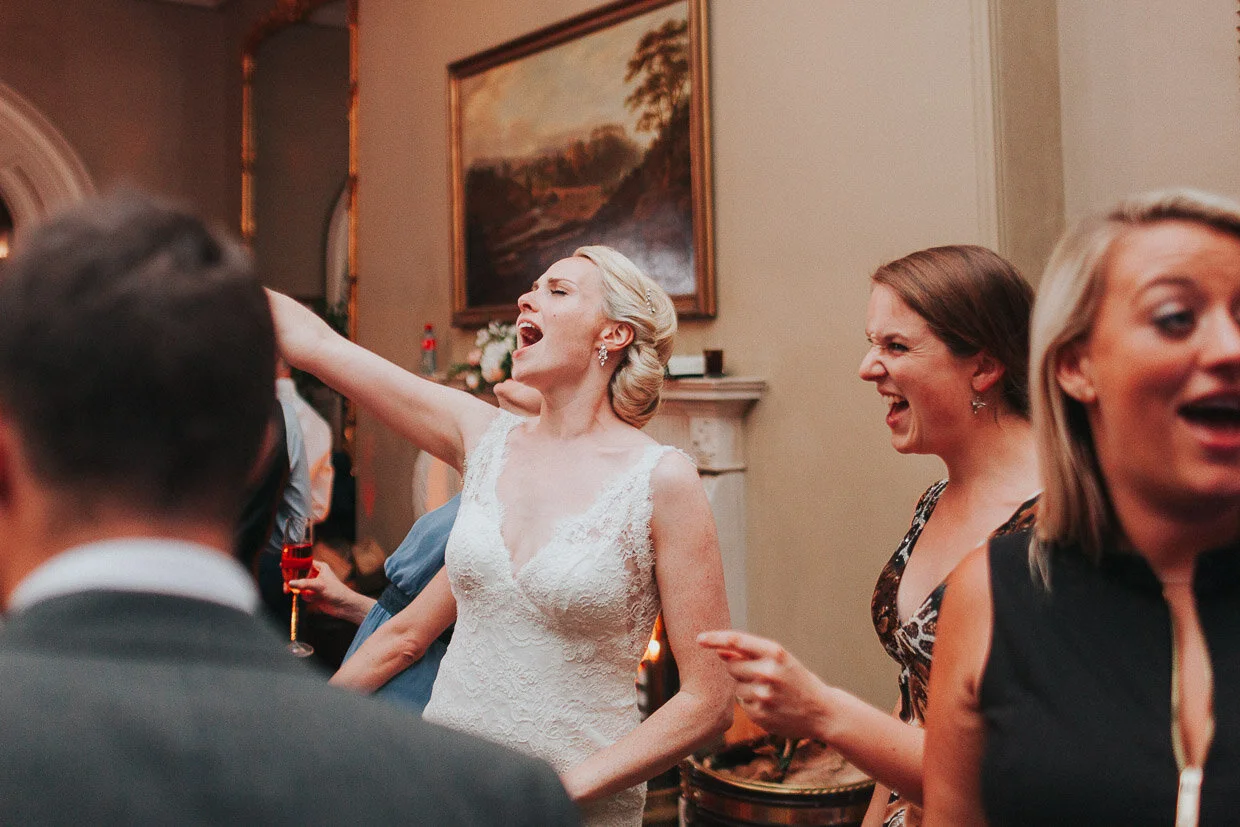 Bride with guests dancing and singing on dancefloor in the main house Wedding couple dancing, facing each other for their first dance in between spotlights on the Ballynatray Estate for a Cork Wedding
