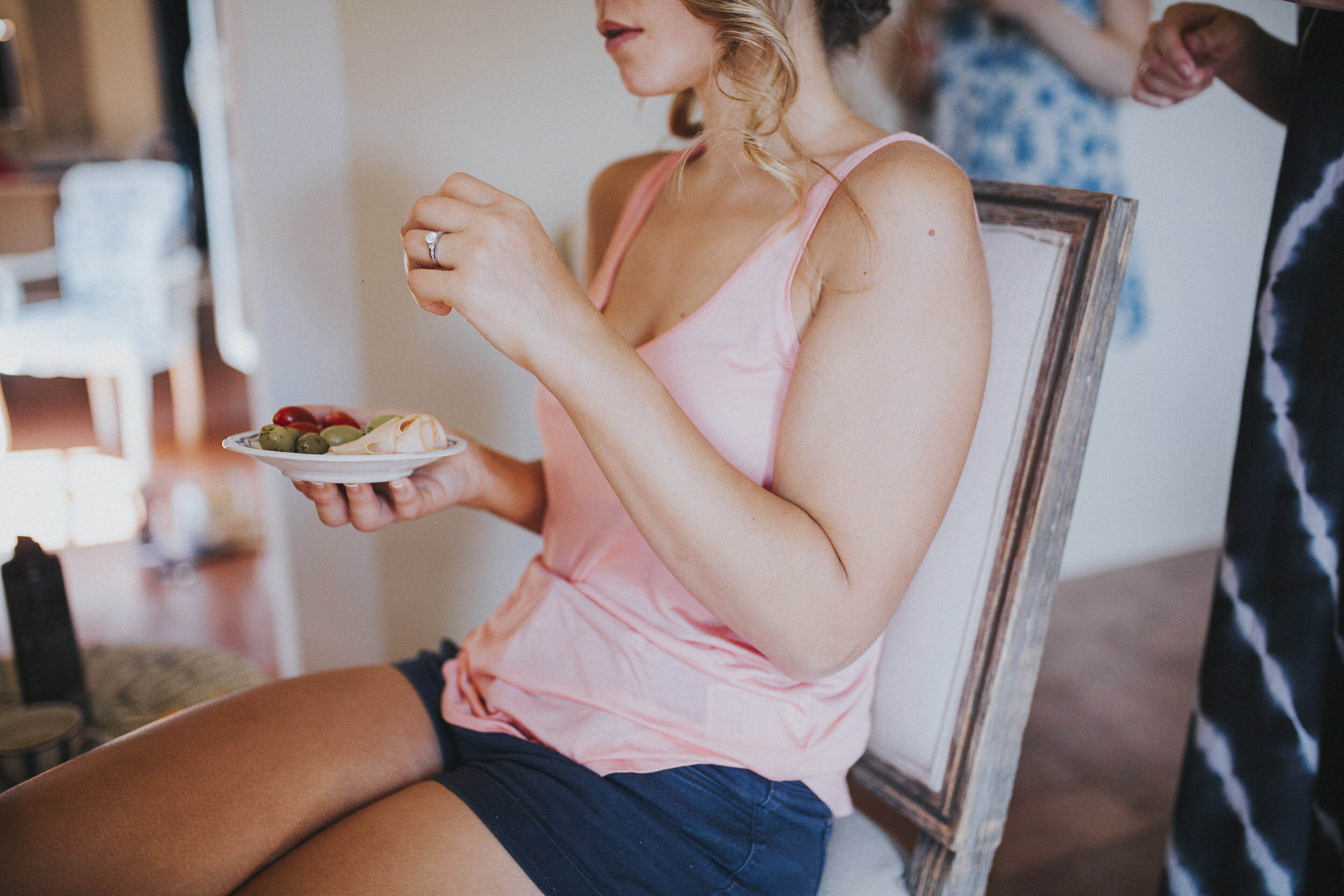 A International Bride sitting in the make-up chair with a small plate of food at Tuscany Wedding Photography