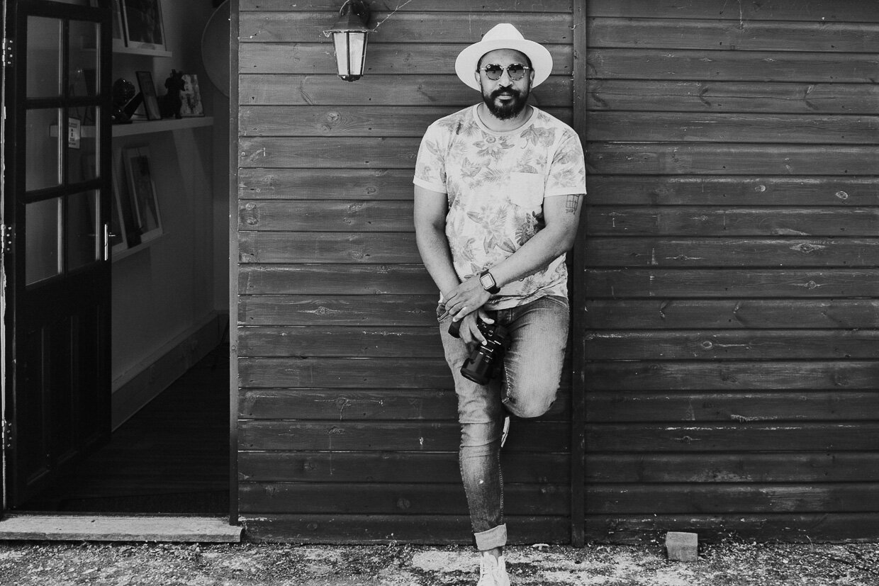 Black & White Portrait of Jay Anderson, West Midlands Wedding Photographer, outside the studio leaning against the wall