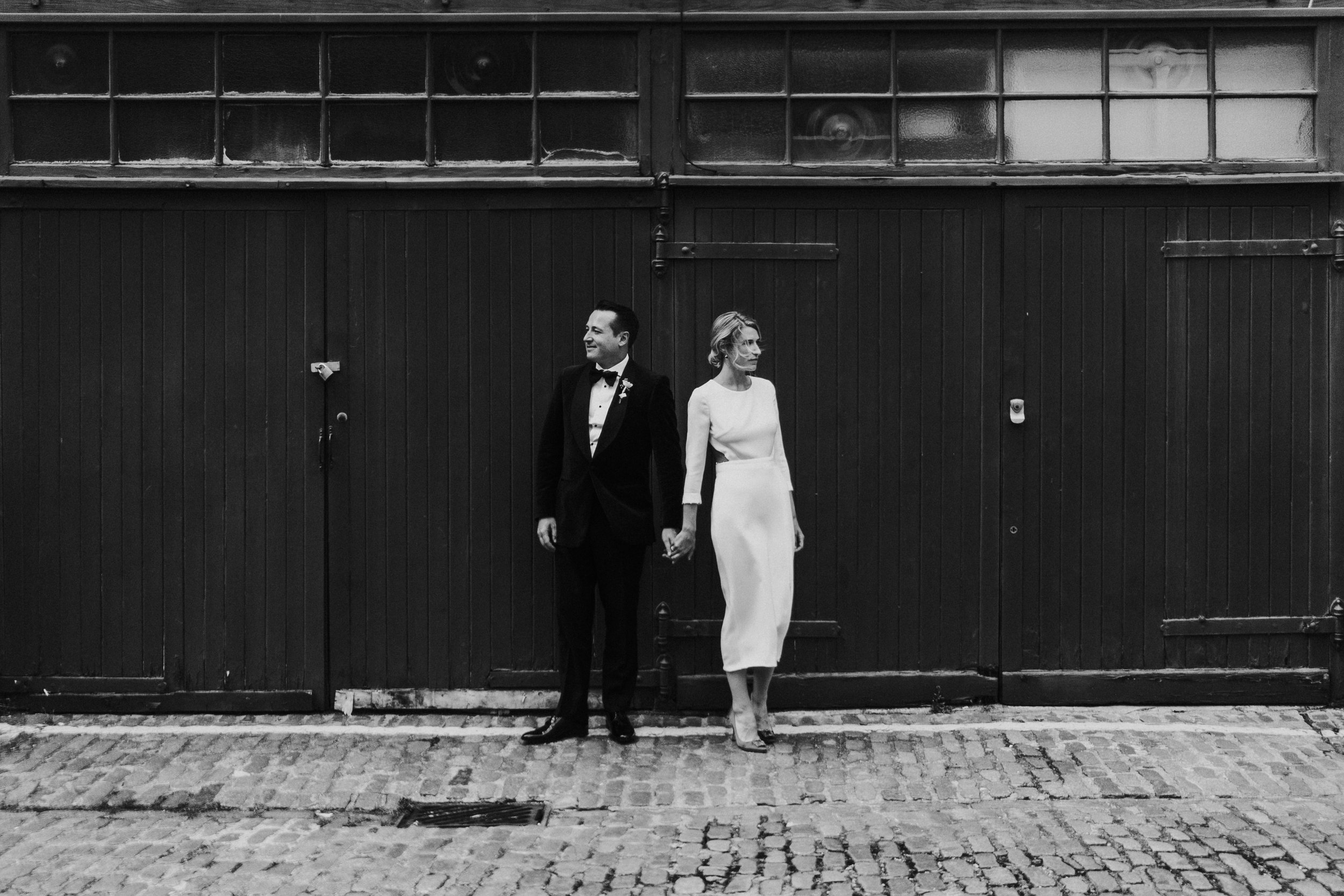 Couple standing together in a London Mews facing away from each other at a Old Marylebone Town Hall Wedding.