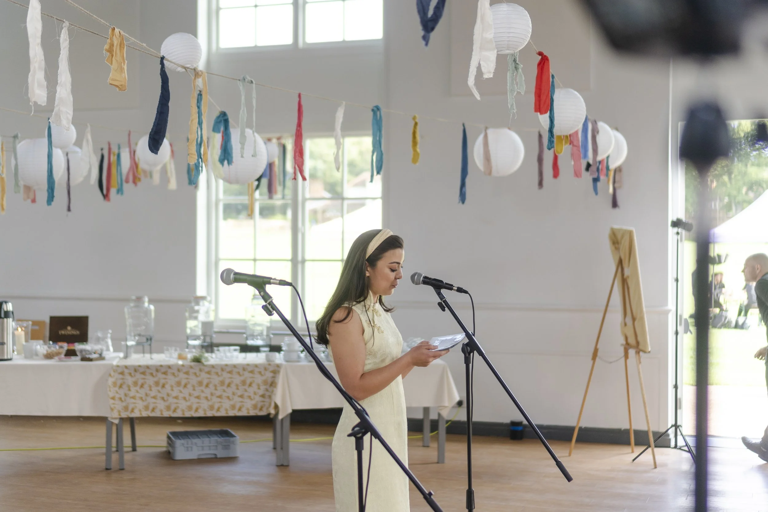 Bridesmaid giving a speech with a microphone in Highgate School at a Highgate, London Wedding.