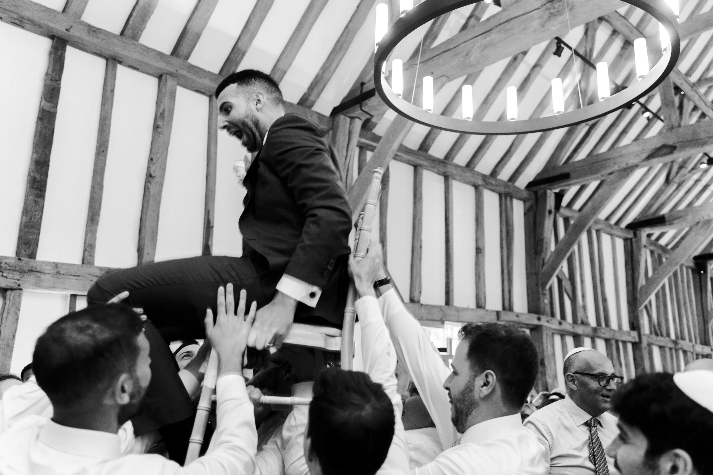  Groom being hoisted on a chair at the Wedding reception party at Micklefield Hall, Buckinghamshire 