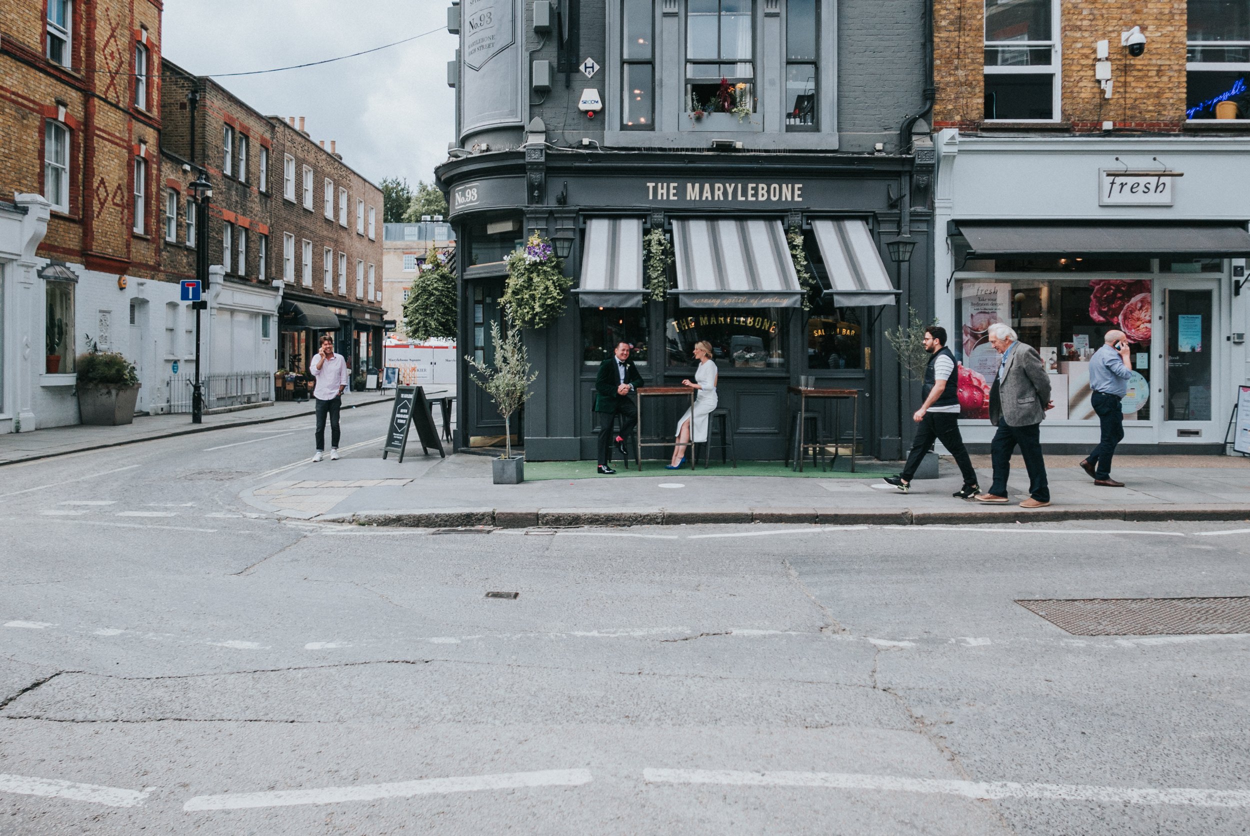 Wedding couple sitting outside The Marylebone Pub before a Old Marylebone Town Hall Wedding