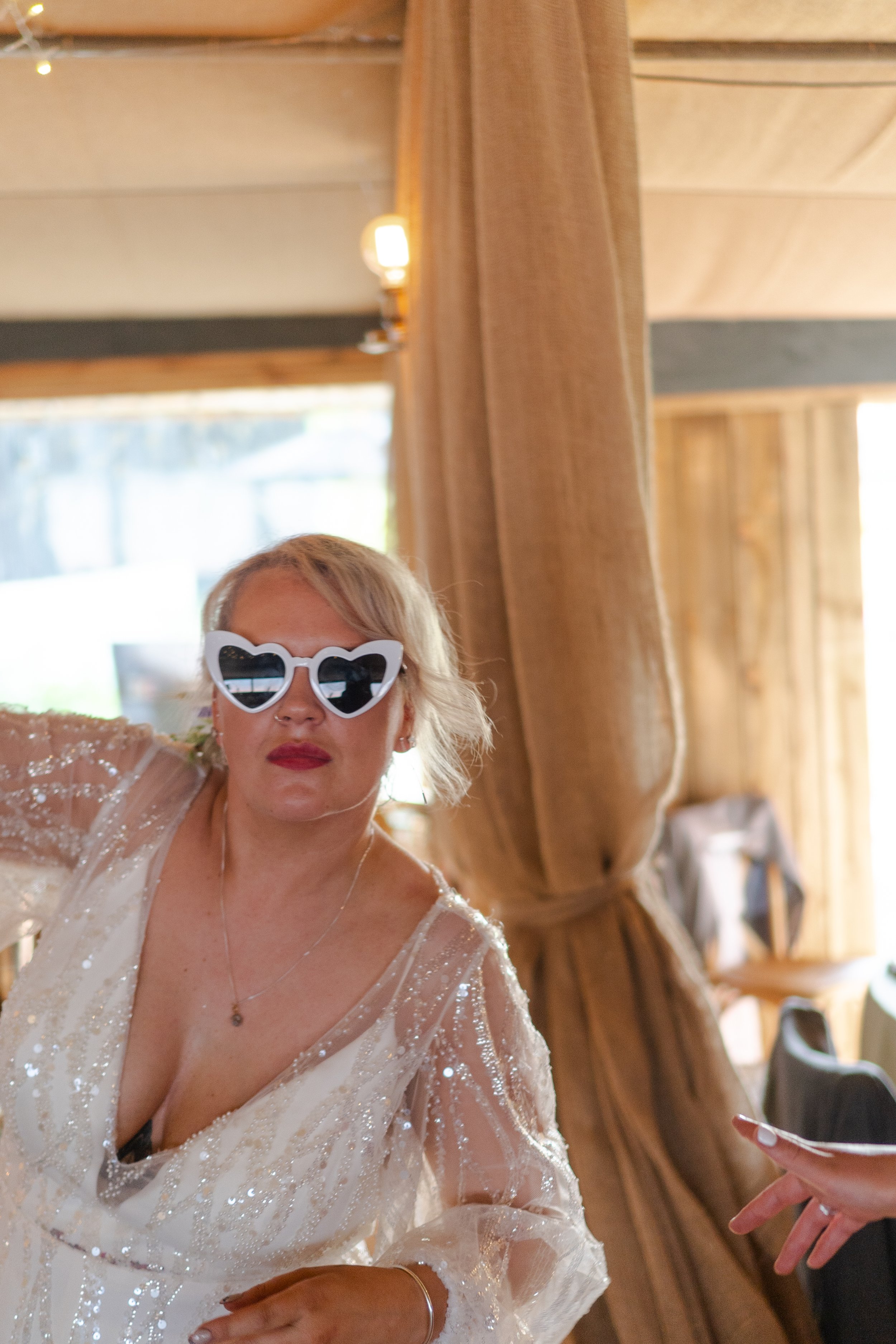 Bride wearing heart-shaped sunglasses looking at the camera