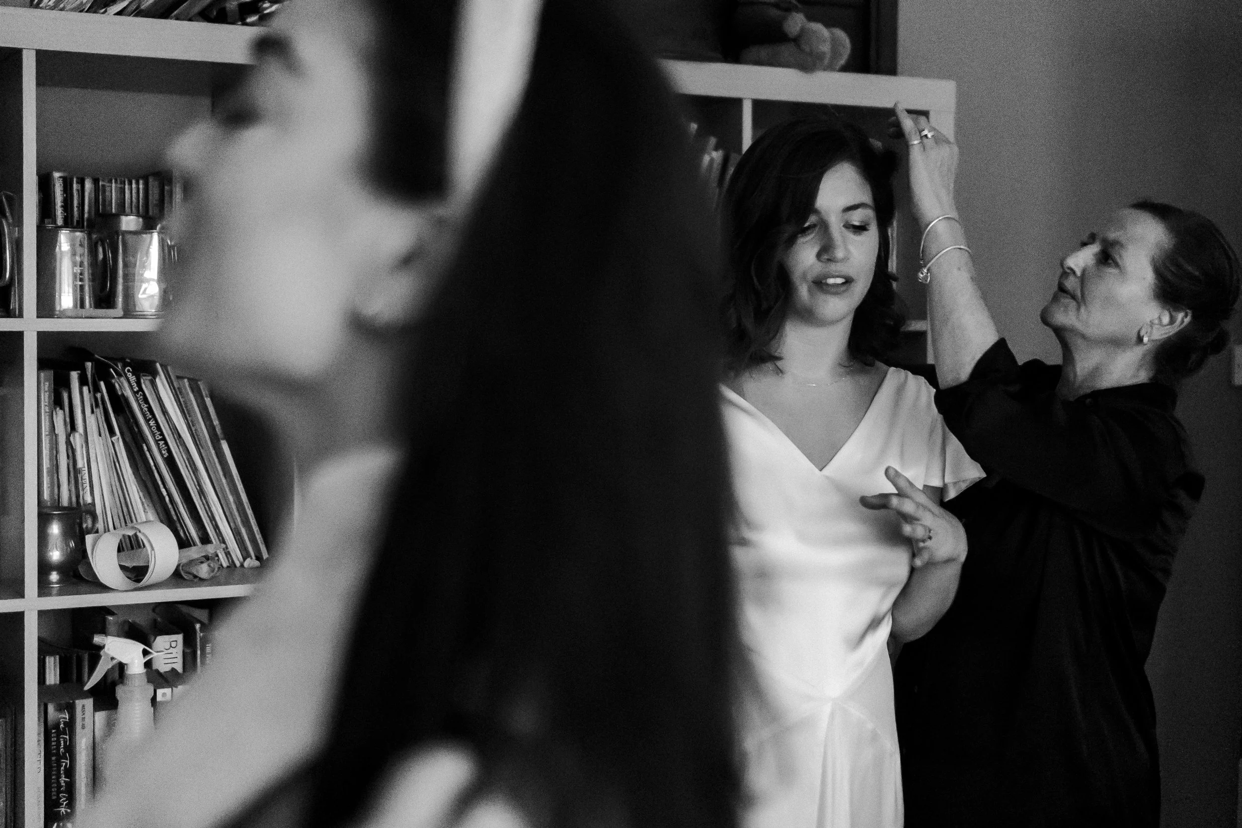 Bride having a few touchups on her hair while the bridesmaids is slightly in shot at a Highgate, London Wedding