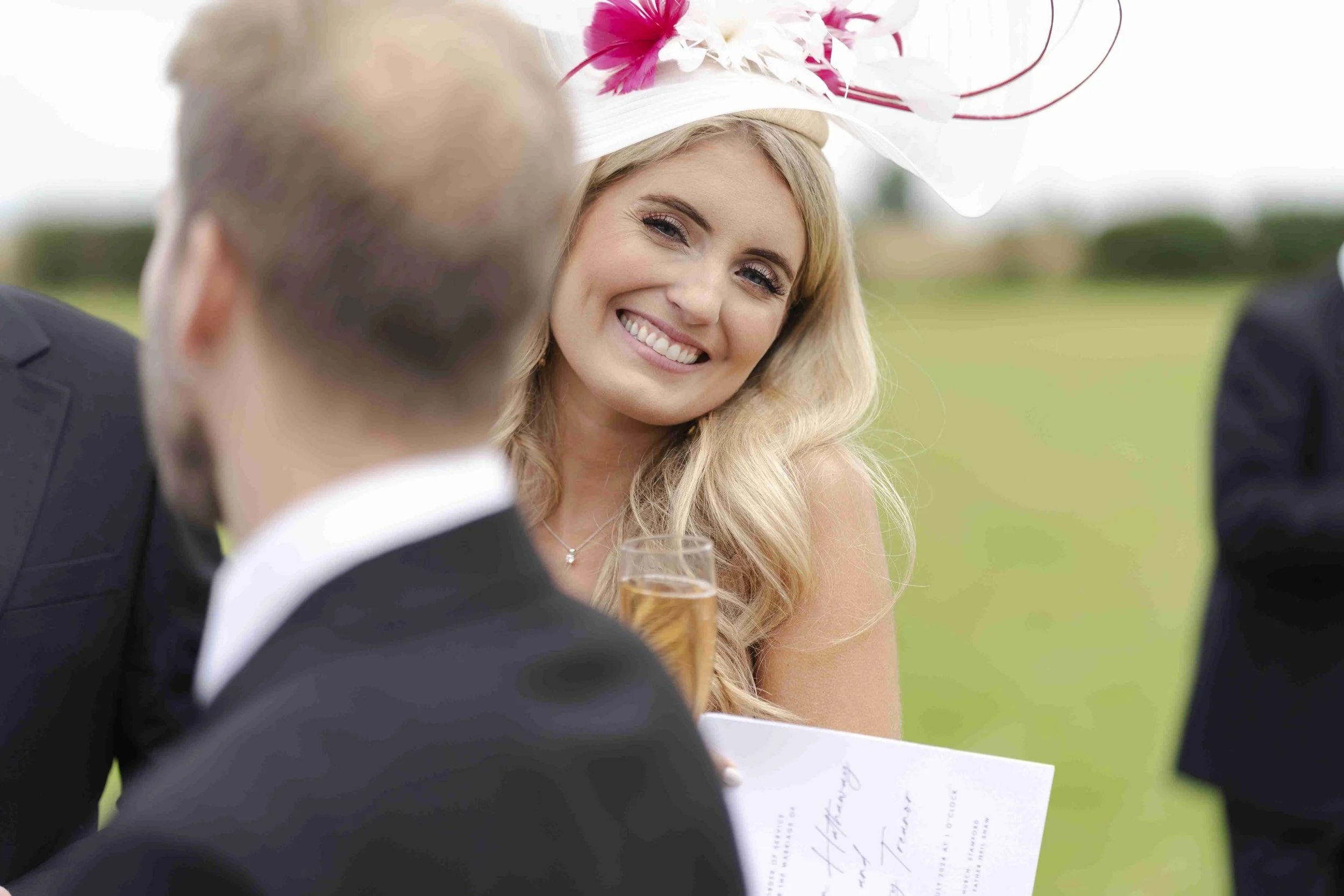 Wedding guest leaning to the side smiling at the camera at the Halfmoon Farm Wedding in Rutland