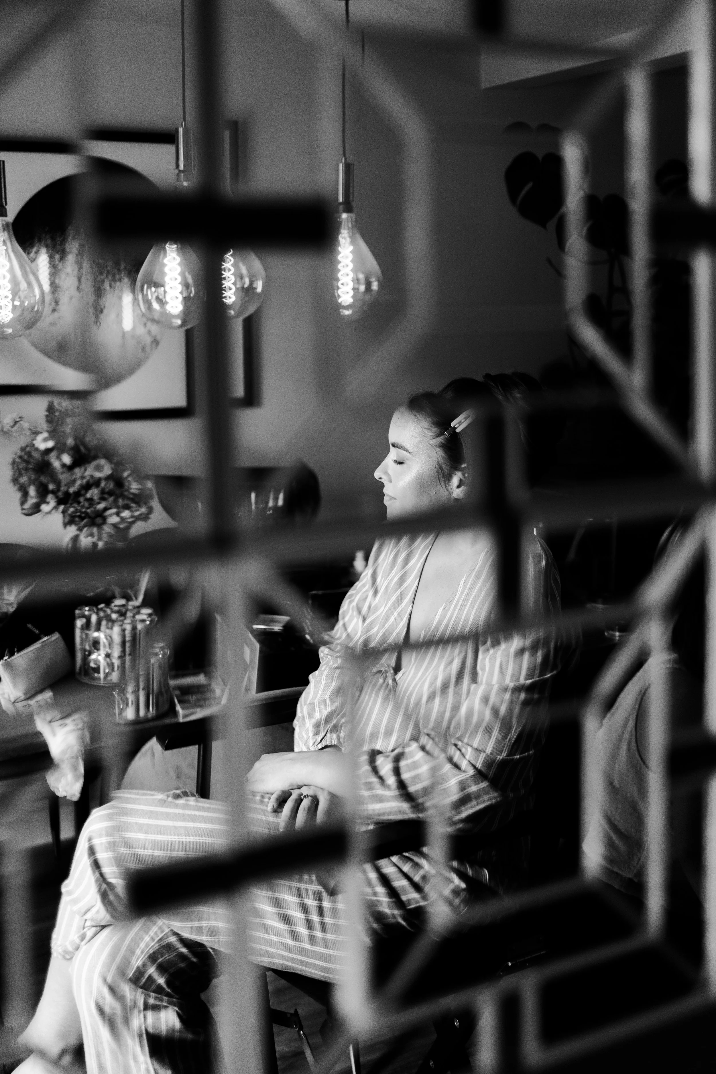 A reflection in the mirror of the Bride sitting in makeup chair with eyes closed before a Worton Kitchen Garden, Oxfordshire Wedding