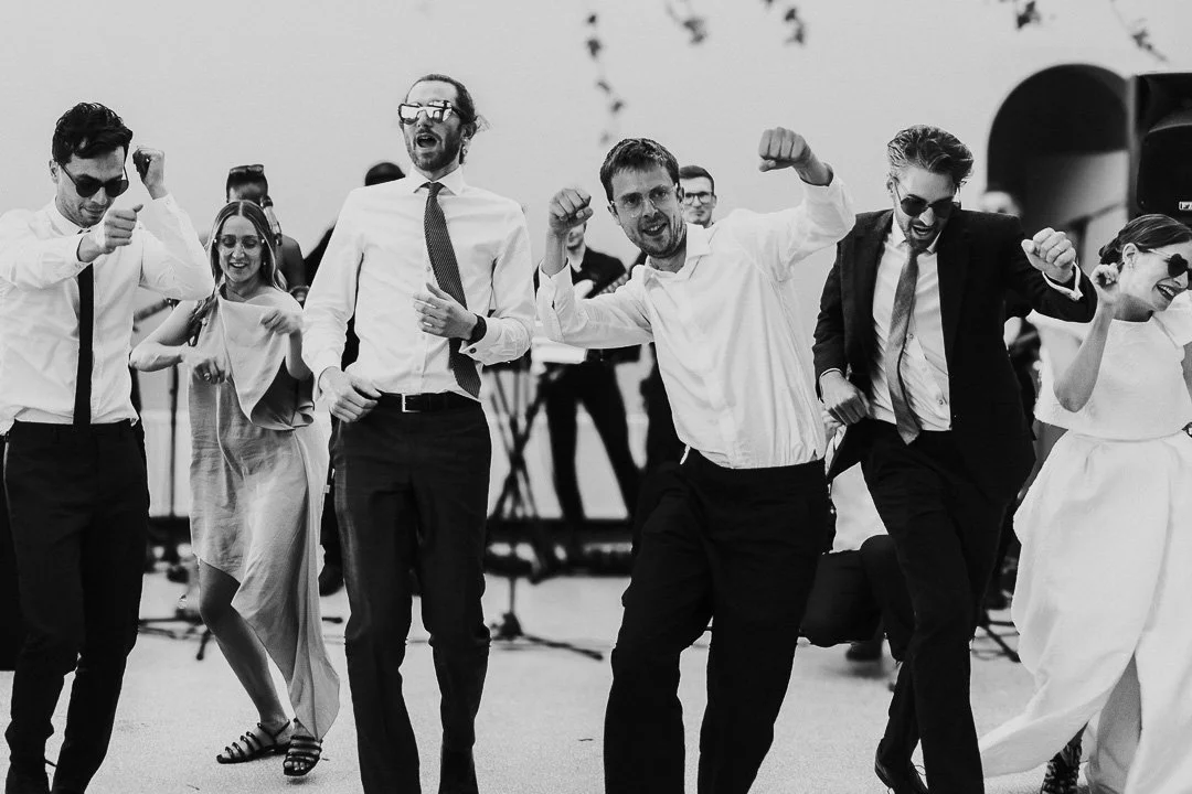Groom and a few guests in sunglasses perform a dance routine on the dance floor at a Hampton Court House Wedding.
