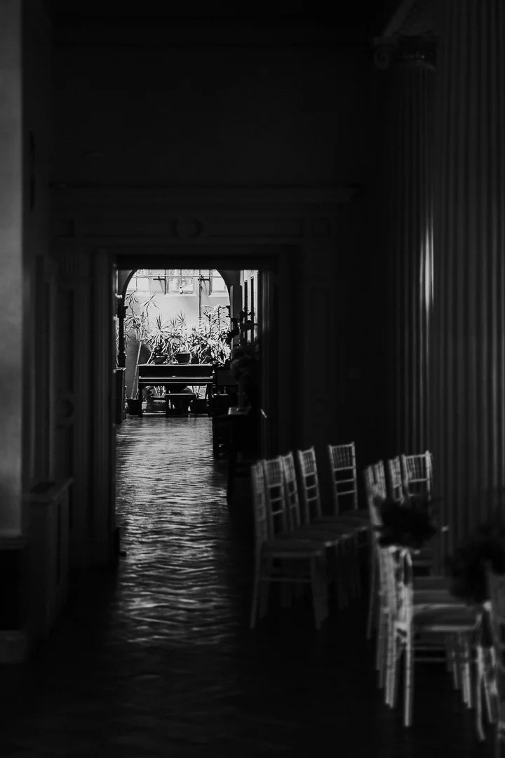 A black & white image with a view through the ceremony view towards the glasshouse at Hampton Court House