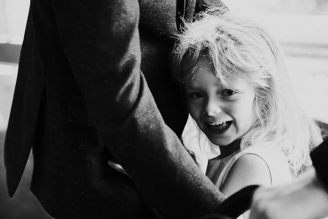 A child guest hugging another guest in the ceremony room at a Hampton Court House Wedding