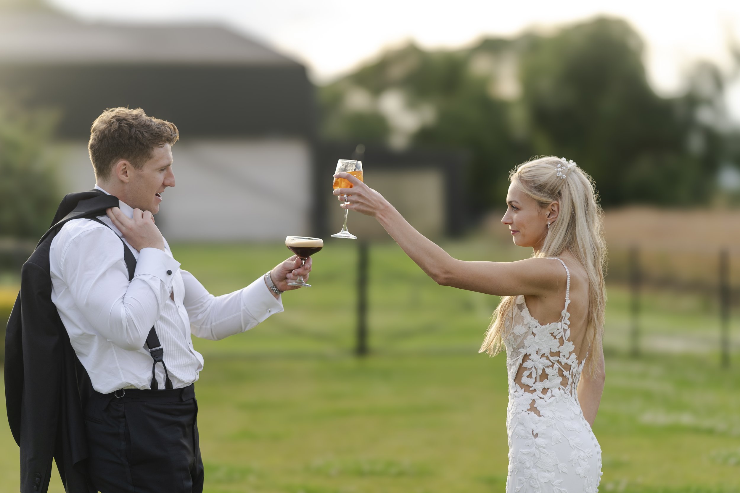 Bride & Groom standing opposite each other and cheesing each other