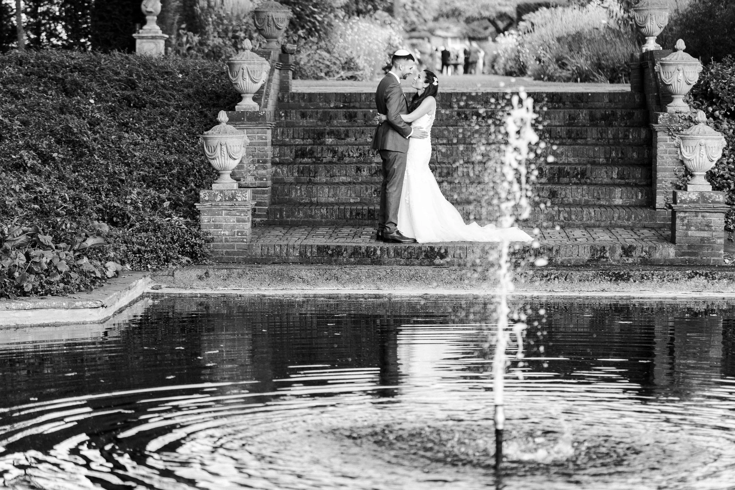 Wedding couple posing in front of the fountain at The Temple at a Micklefield Hall Wedding