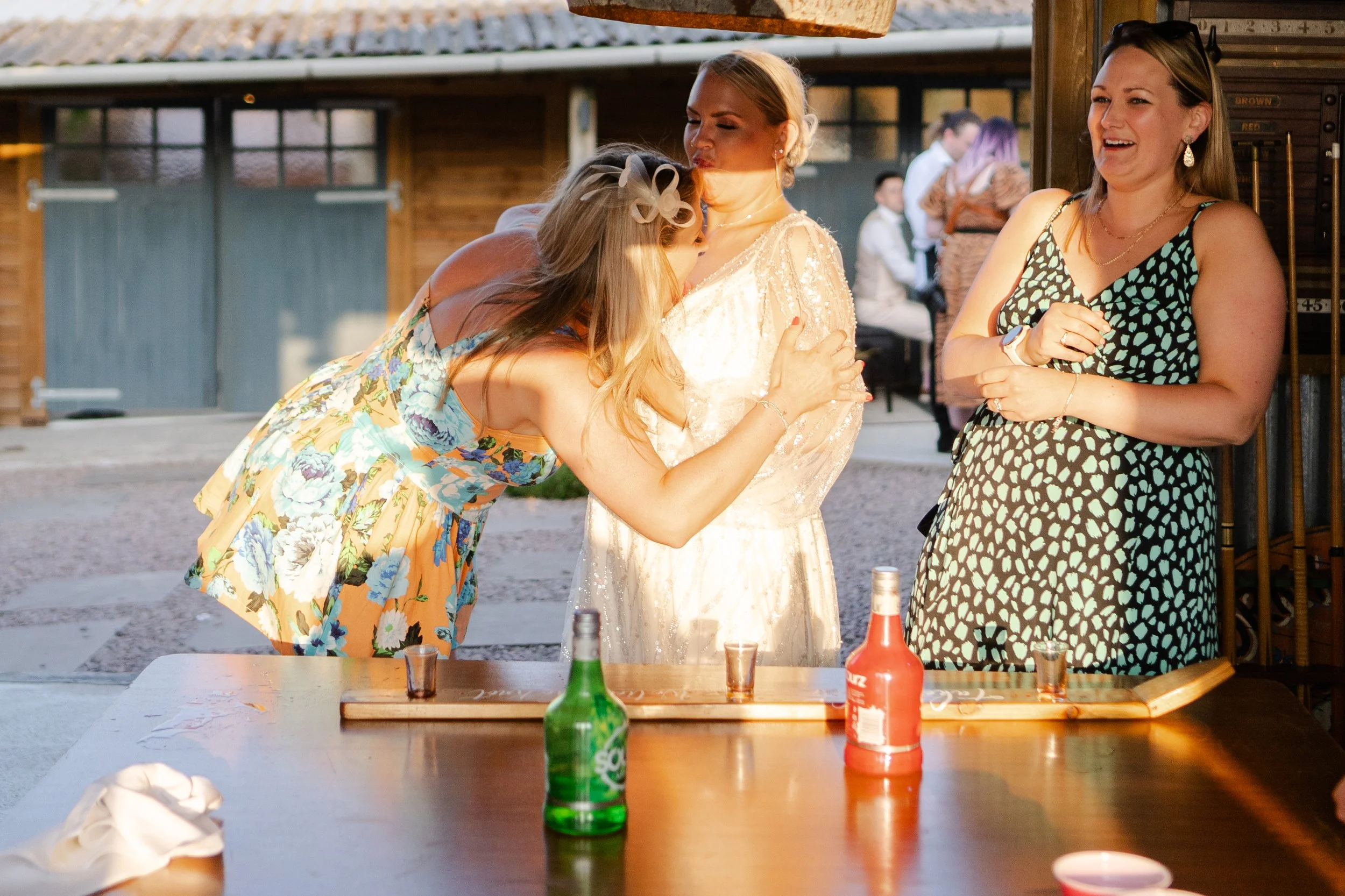 Wedding guest drinking from Bride's chest in the evening sun at a rhyse farm wedding