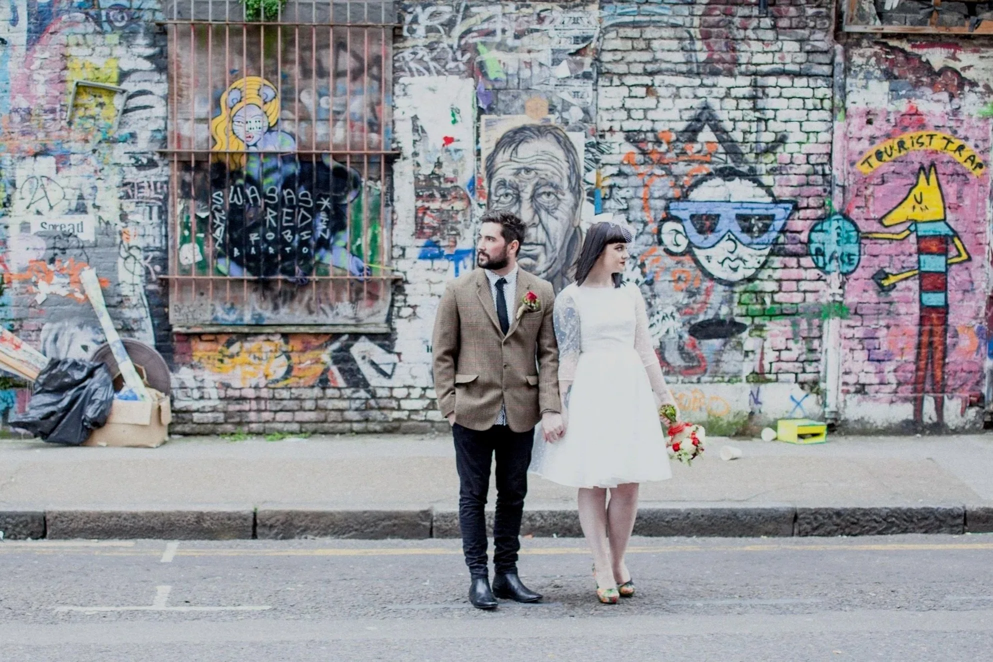 Wedding couple standing in front of a wall with graffiti art at a London Wedding
