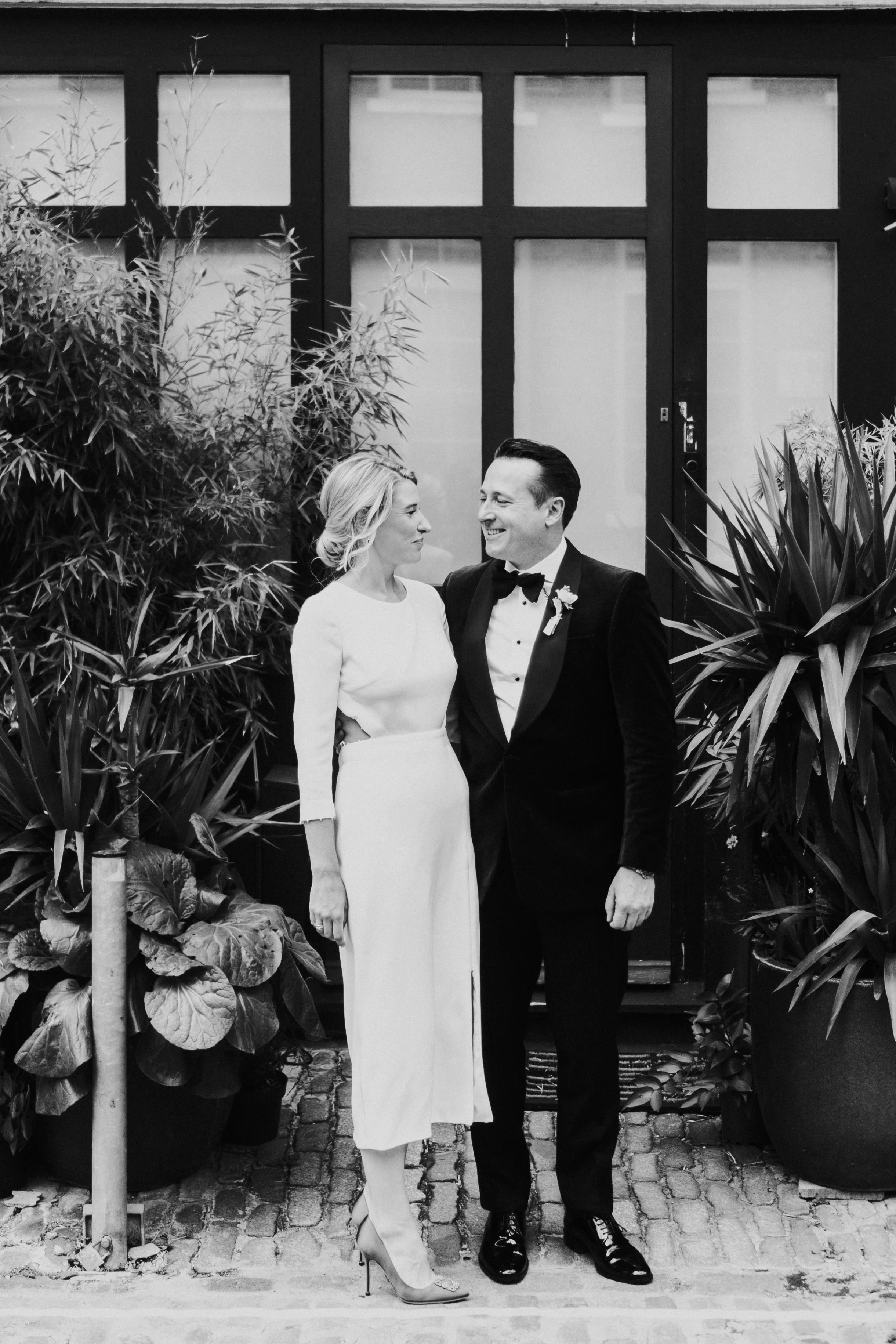 Bride & Groom standing outside looking at each other smiling at a Old Marylebone Town Hall Wedding