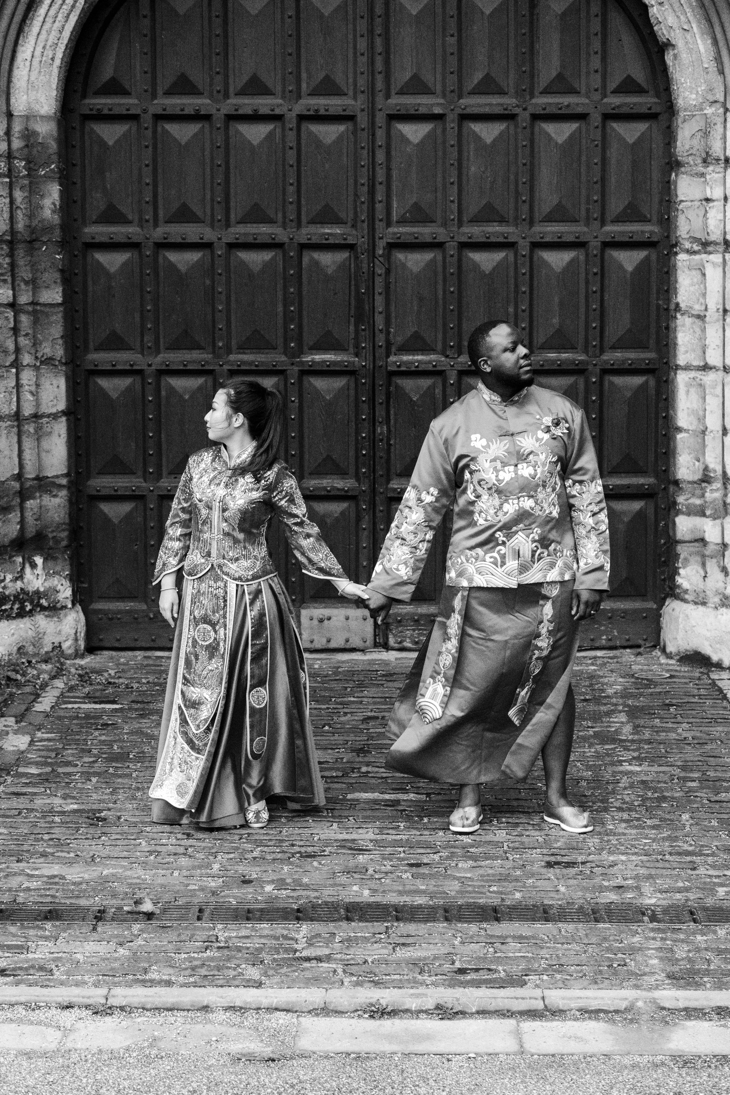 A wedding couple standing outside large wooden doors for Lambeth Palace, London for a Garden Museum, London Wedding.