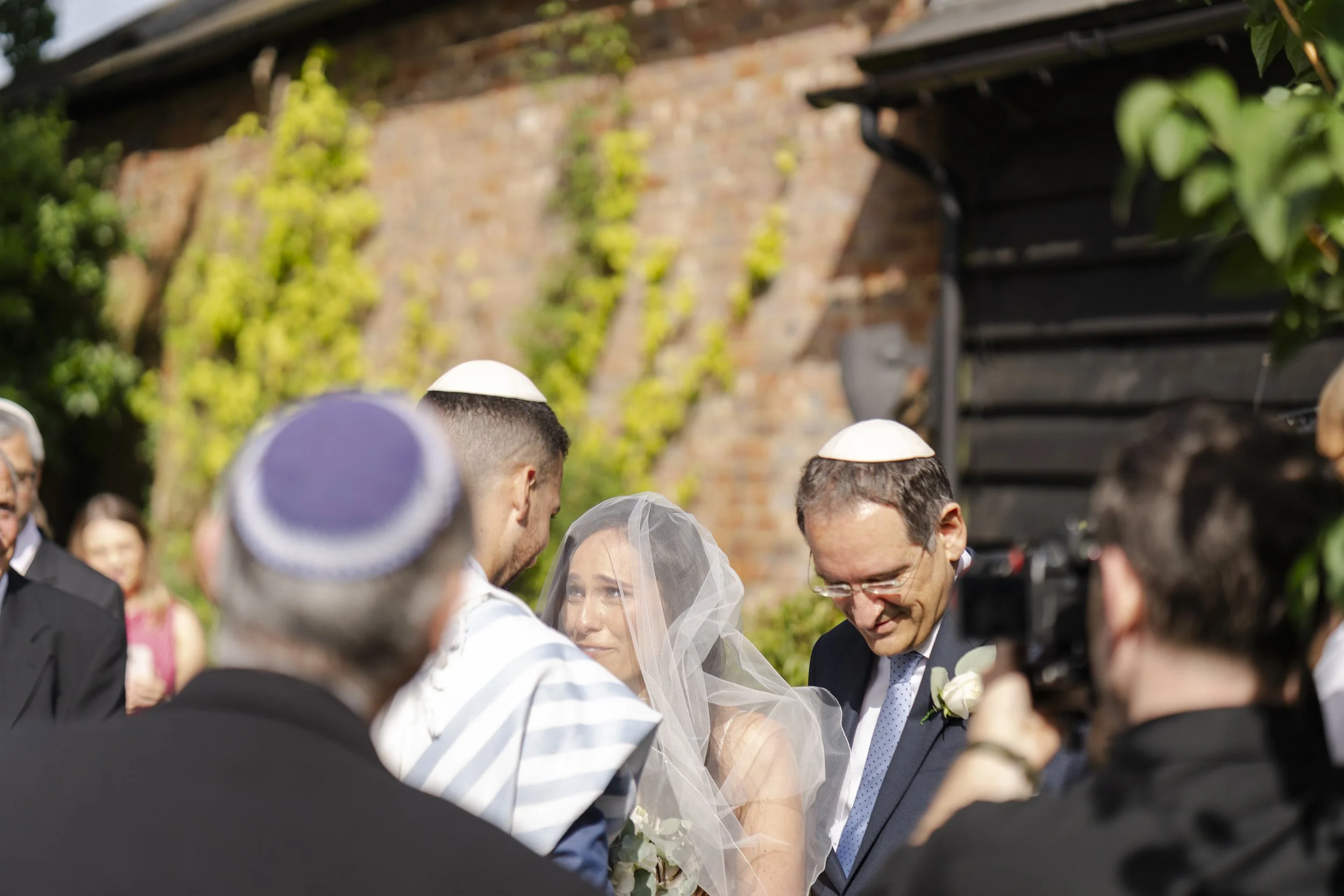 Couple standing together at The Temple with family members around them at a Micklefield Hall Wedding