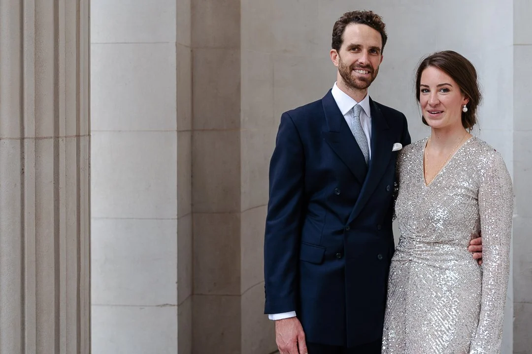 Wedding couple next to the Pillars looking and smiling at the camera at the Old Marylebone Town Hall Wedding.