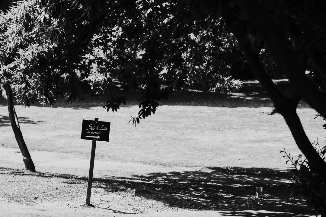 A sign in the lawn with an arrow below lettering showing the way to the reception area at a Hampton Court House Wedding.