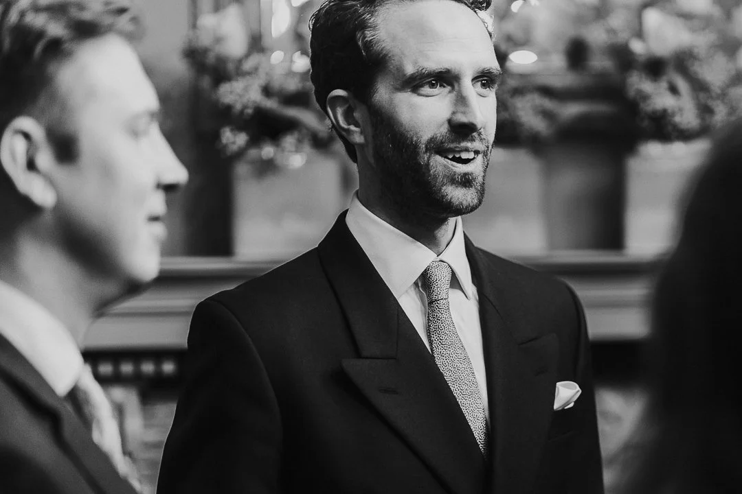 Groom looking forward and smiling in the ceremony room at the Old Marylebone Town Hall Wedding.