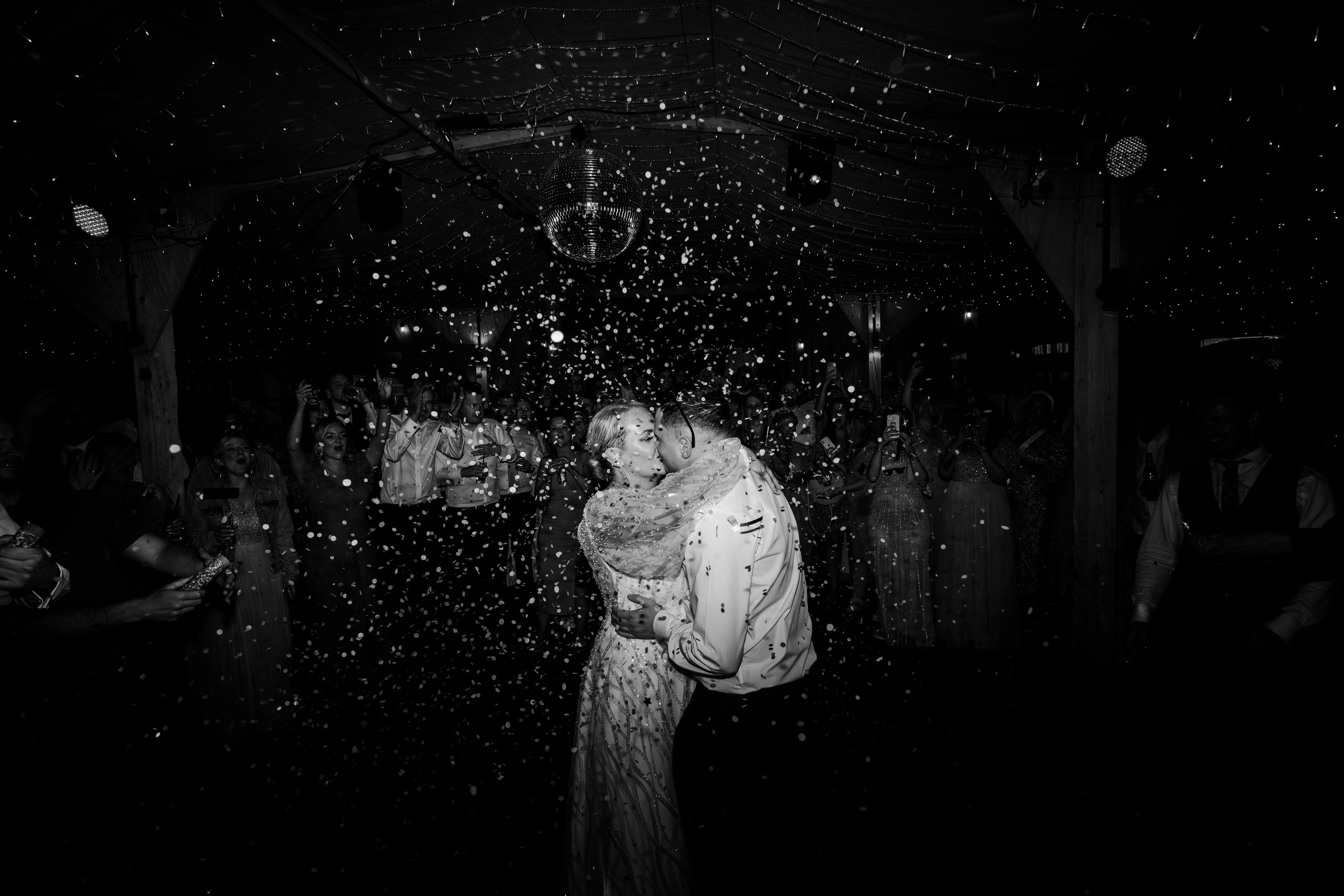 Wedding couple showered with confetti while on the dancefloor kissing at a wedding reception at a rhyse farm wedding