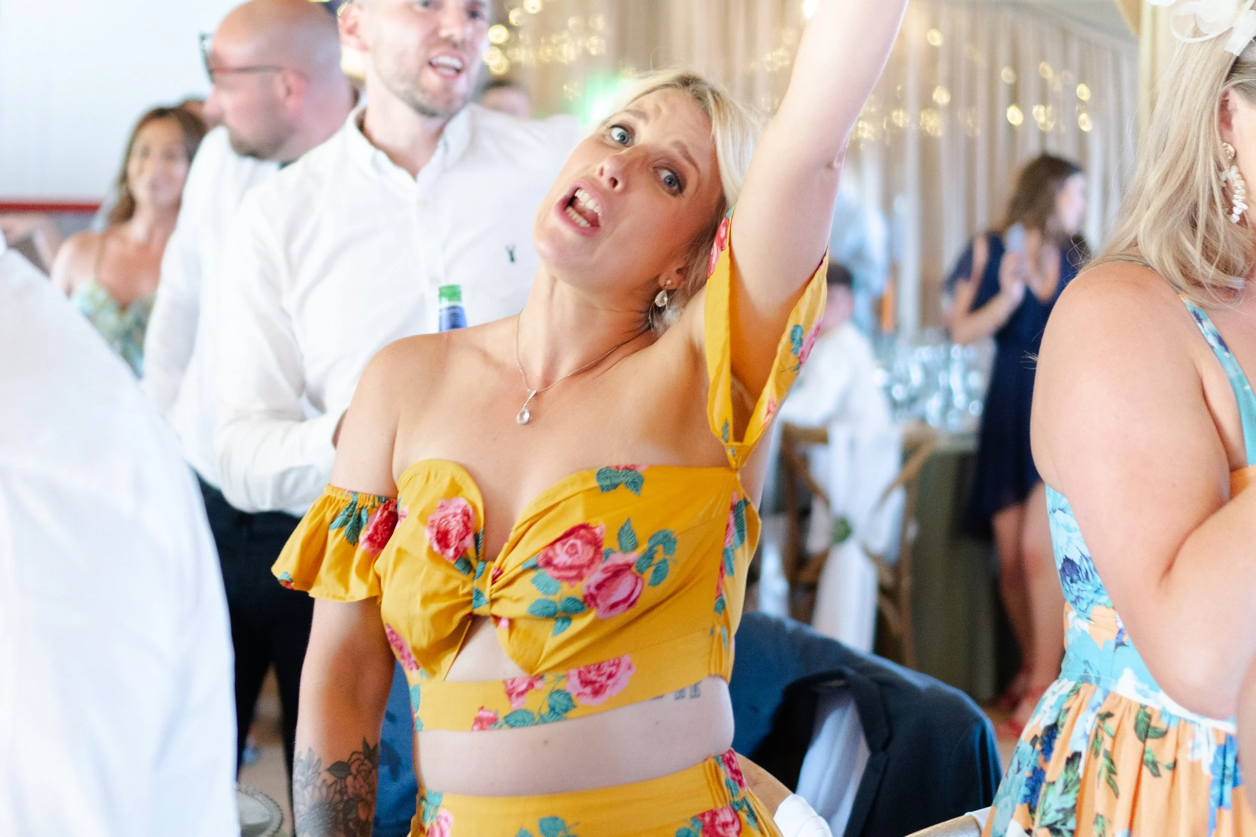 Wedding guest dancing with arm raised in the air at a rhyse farm wedding