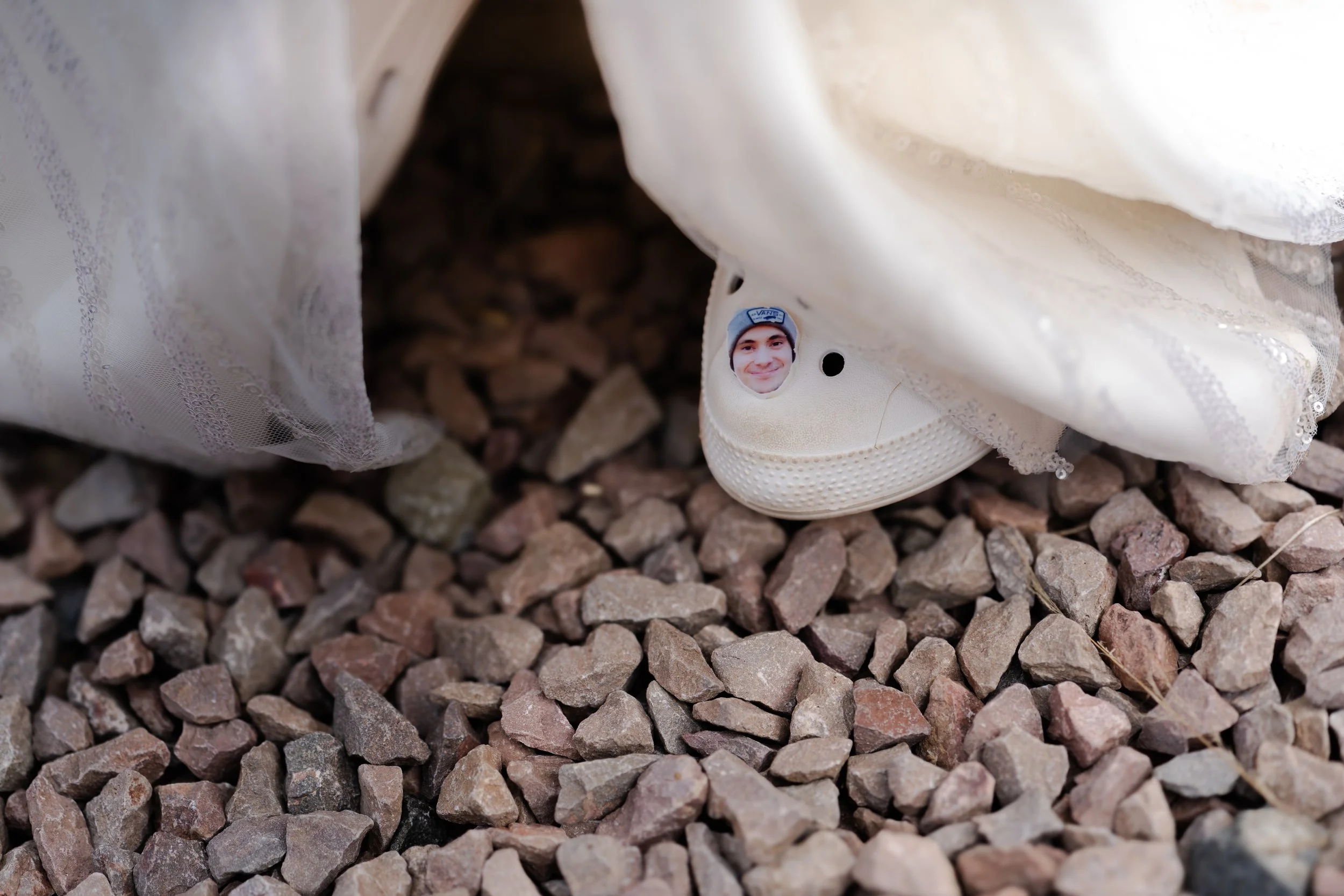 Bride wearing Crocs with a pin of Groom attached the shoe at a a rhyse farm wedding