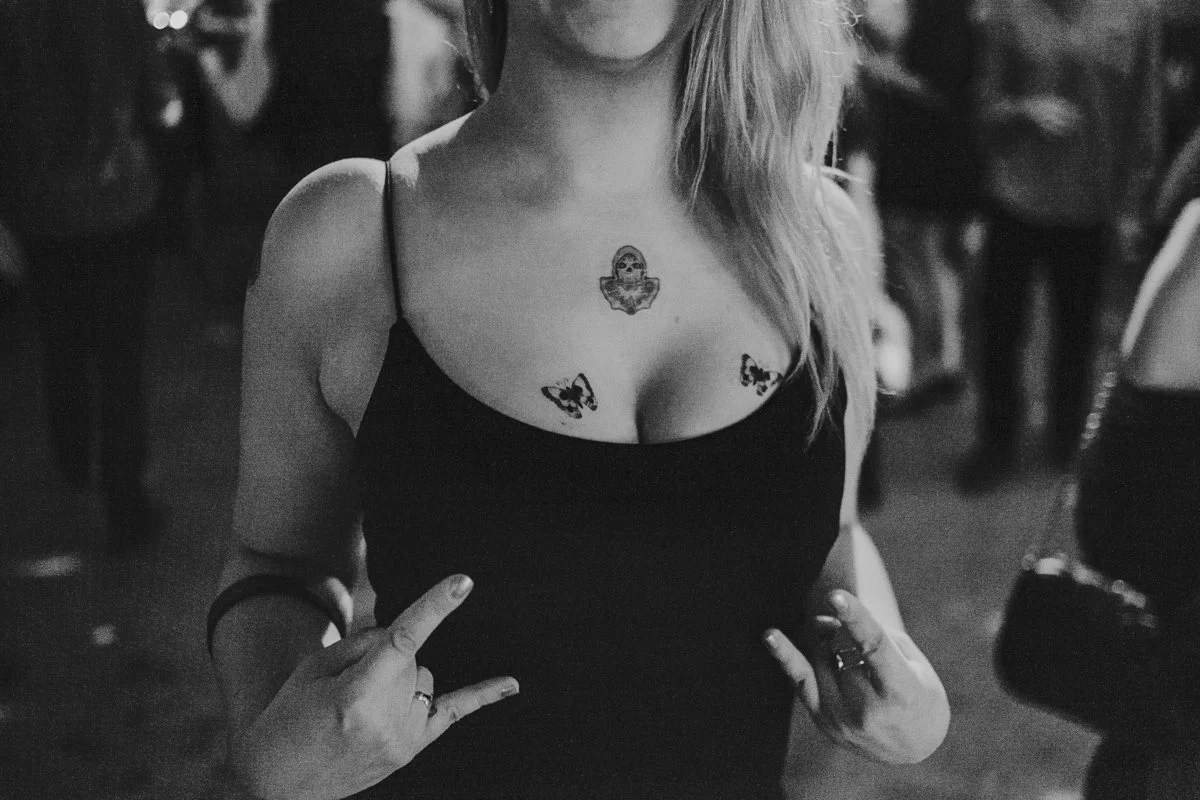 Wedding guest with butterfly tattoos posing inside the iconic The Old Queen’s Head pub on Essex Road, Islington during a London wedding.