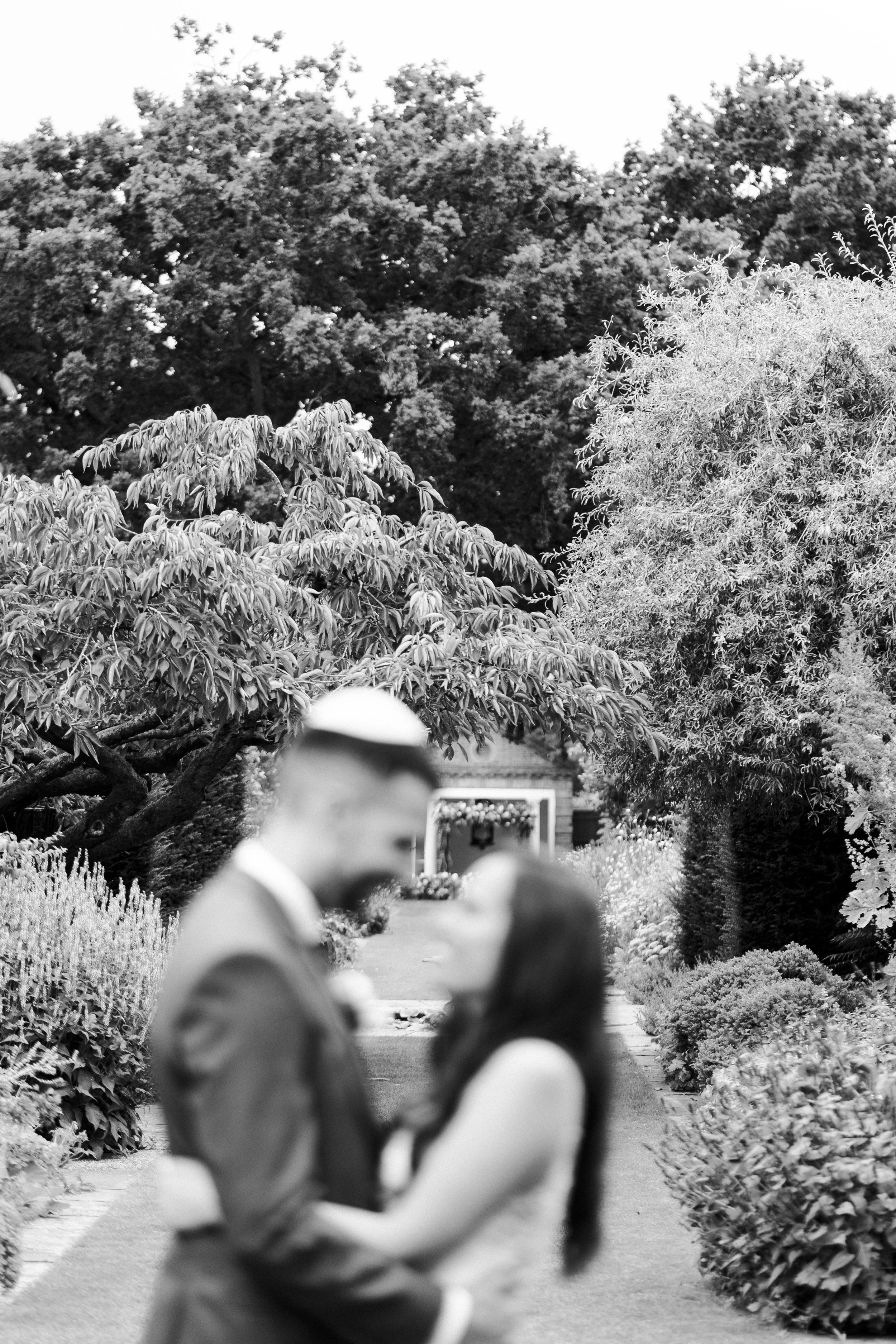 Blurred Wedding couple standing & facing each other with The Temple in the background at a Micklefield Hall Wedding
