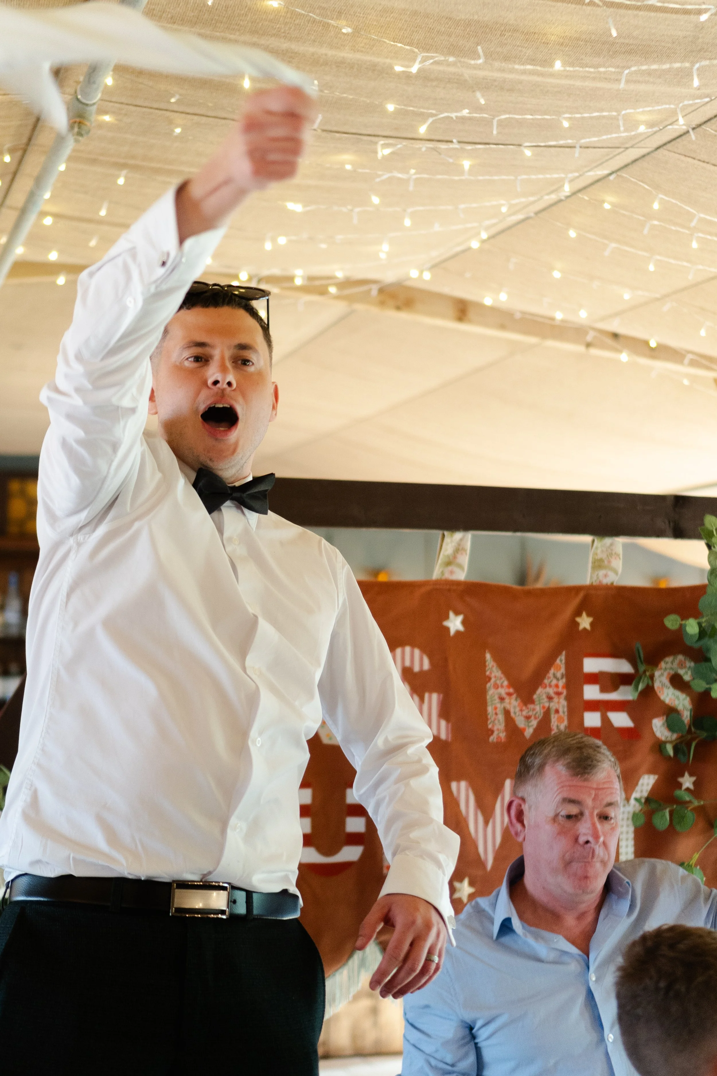 Groom dancing and waving his napkin over his head at a rhyse farm wedding