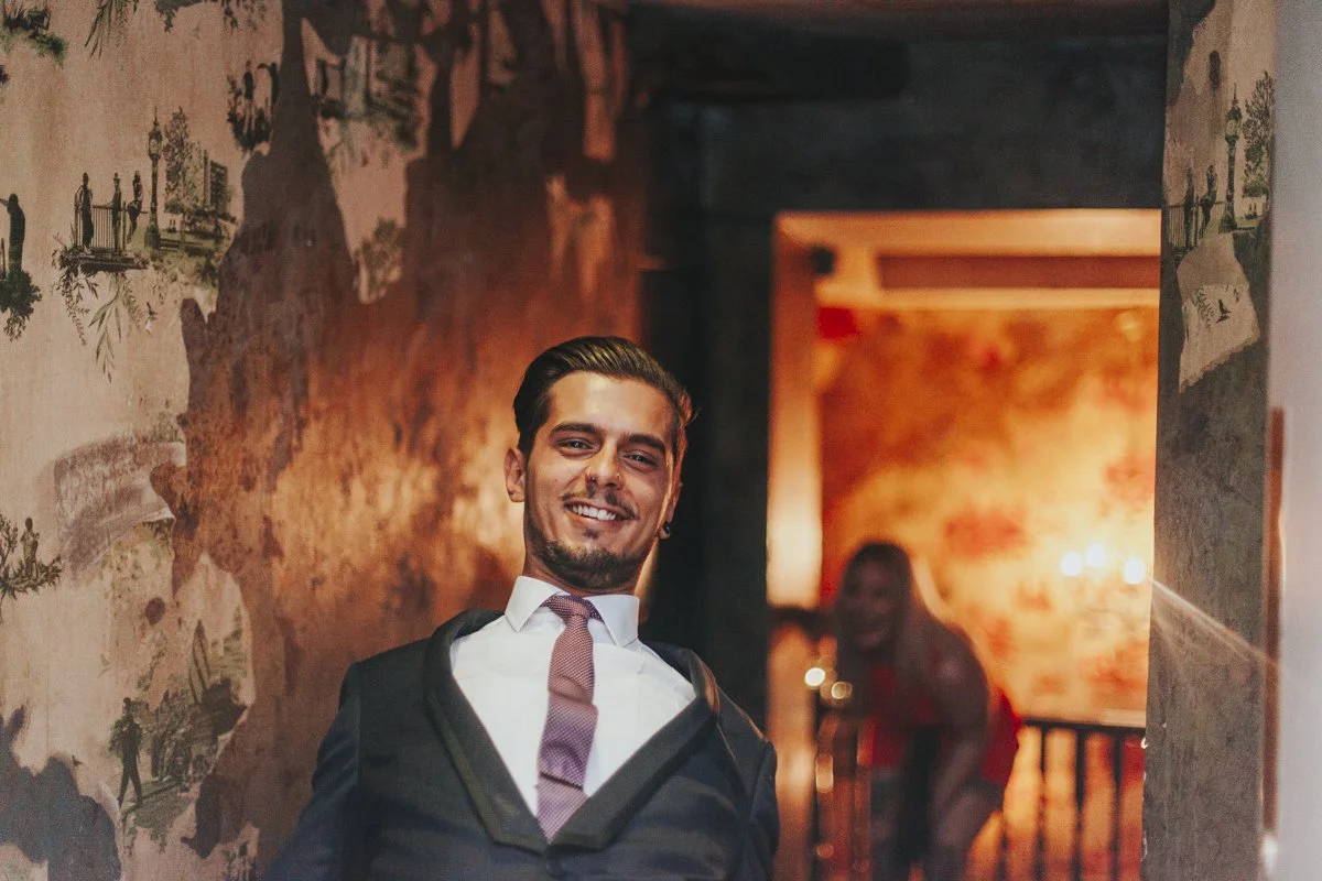 Guest leaning back funnily while walking into a wedding reception at the iconic The Old Queens Head pub, Essex Road, Islington at a London Wedding