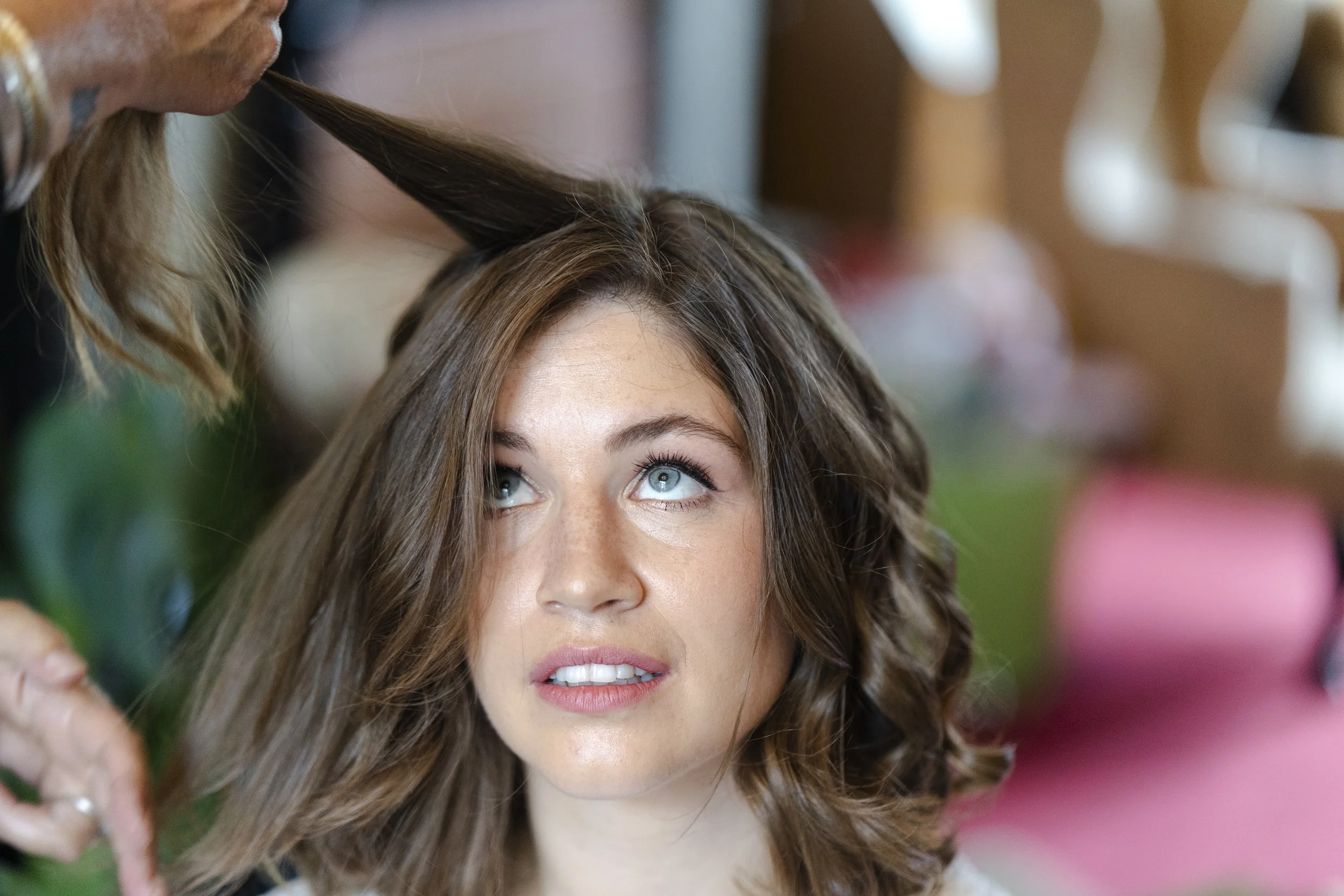 Bride looking up as her hair is pulled up at a Highgate, London Wedding