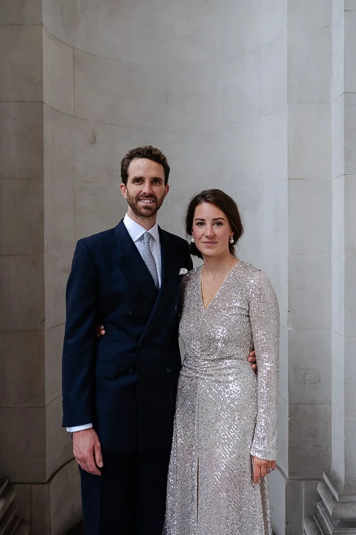 Bride & Groom standing in between the pillars both looking at the camera smiling at the Old Marylebone Town Hall Wedding.