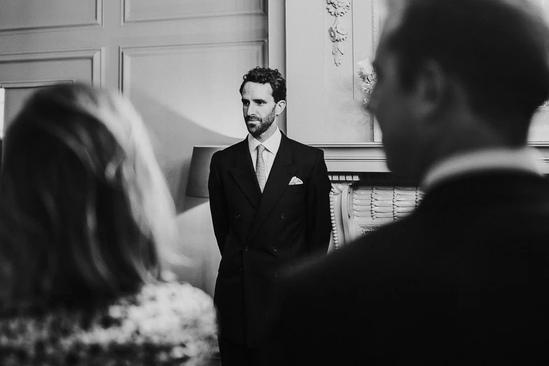 Groom standing on his own with a look of contemplation in the ceremony room at the Old Marylebone Town Hall Wedding