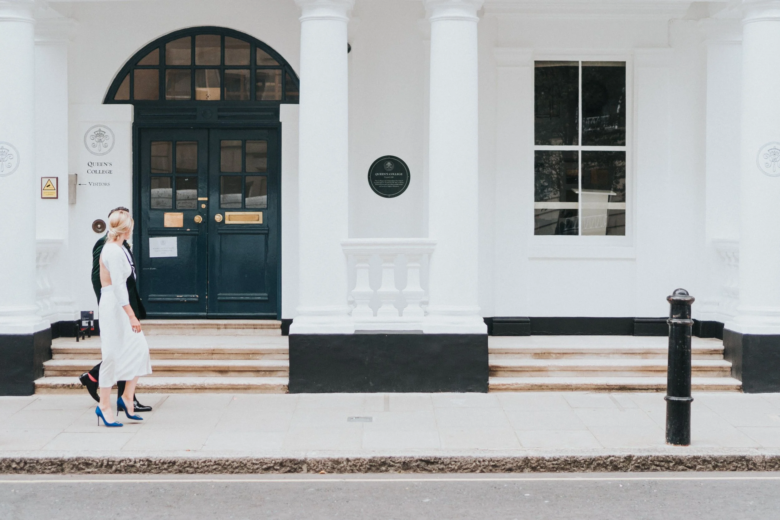 Wedding couple walking down a street pasting a Green door before a Old Marylebone Town Hall Wedding