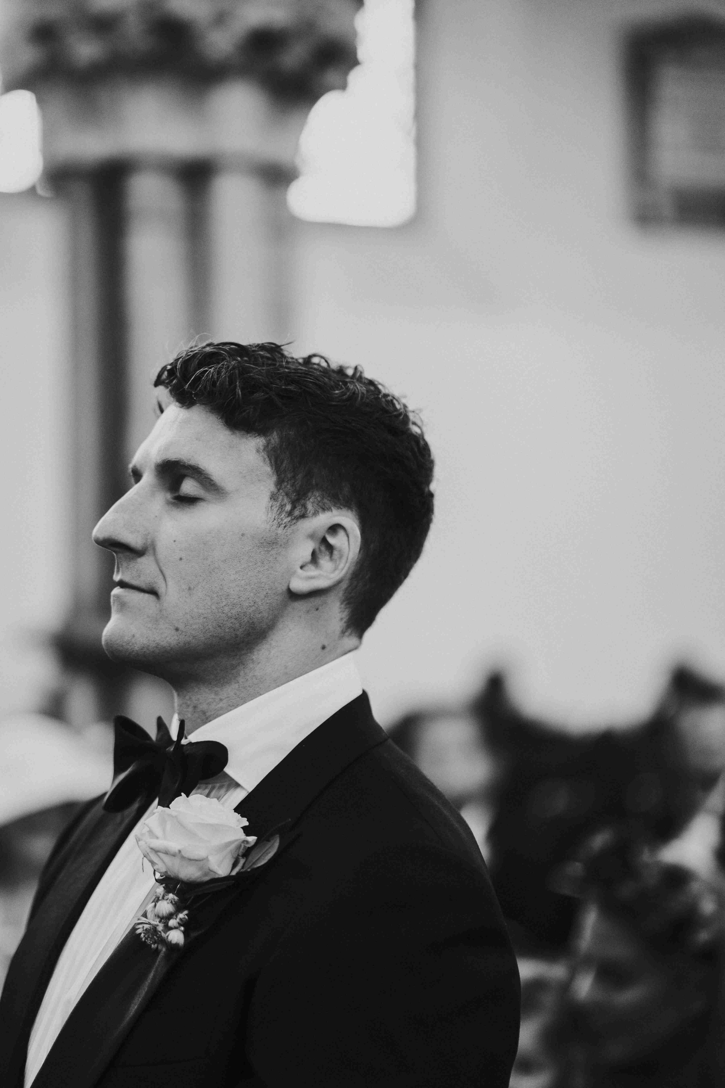 Groom standing at the altar with his eyes closed contemplating at the Halfmoon Farm Wedding in Rutland