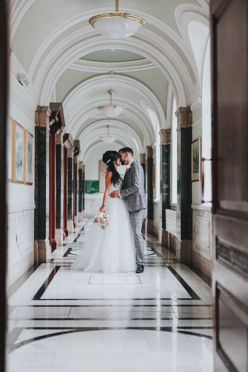 Bride & Groom kissing in the iconic hallway at Islington Town Hall Wedding Venue