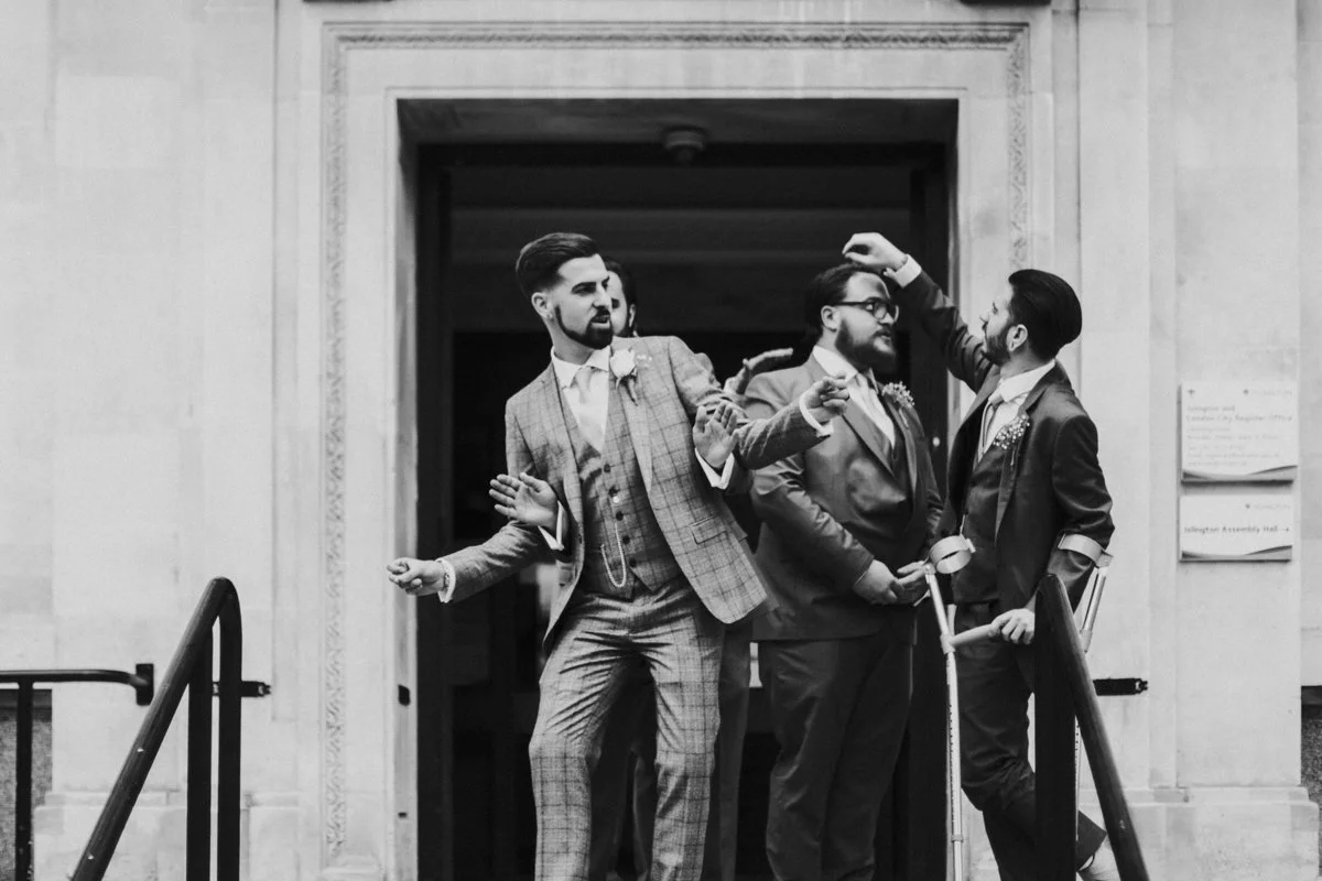 Groom and Groomsmen, messing about on the steps outside Islington Town Hall Wedding Venue