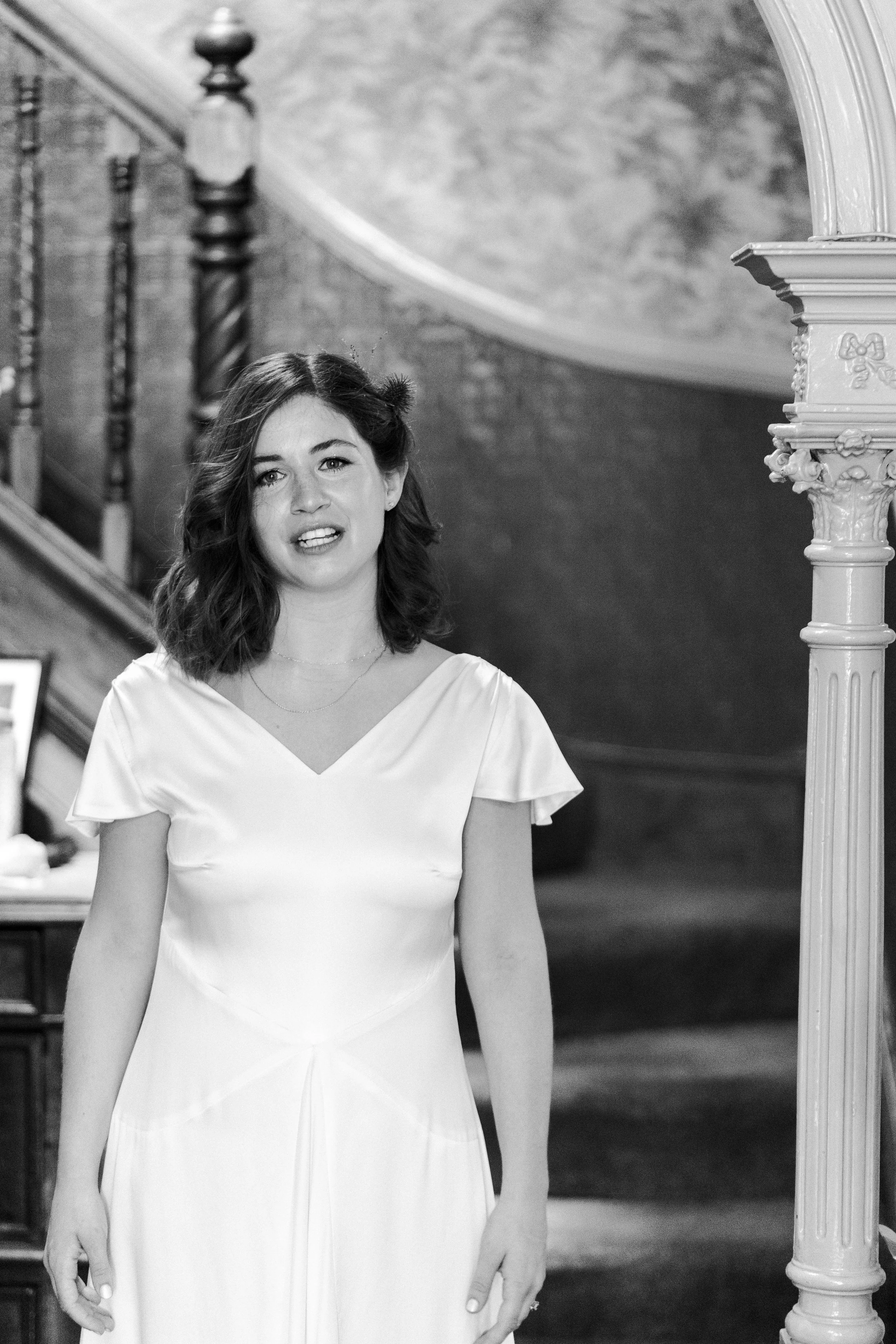 Bride at a bottom of the stairs at the house smiling at the camera before a Highgate, London Wedding